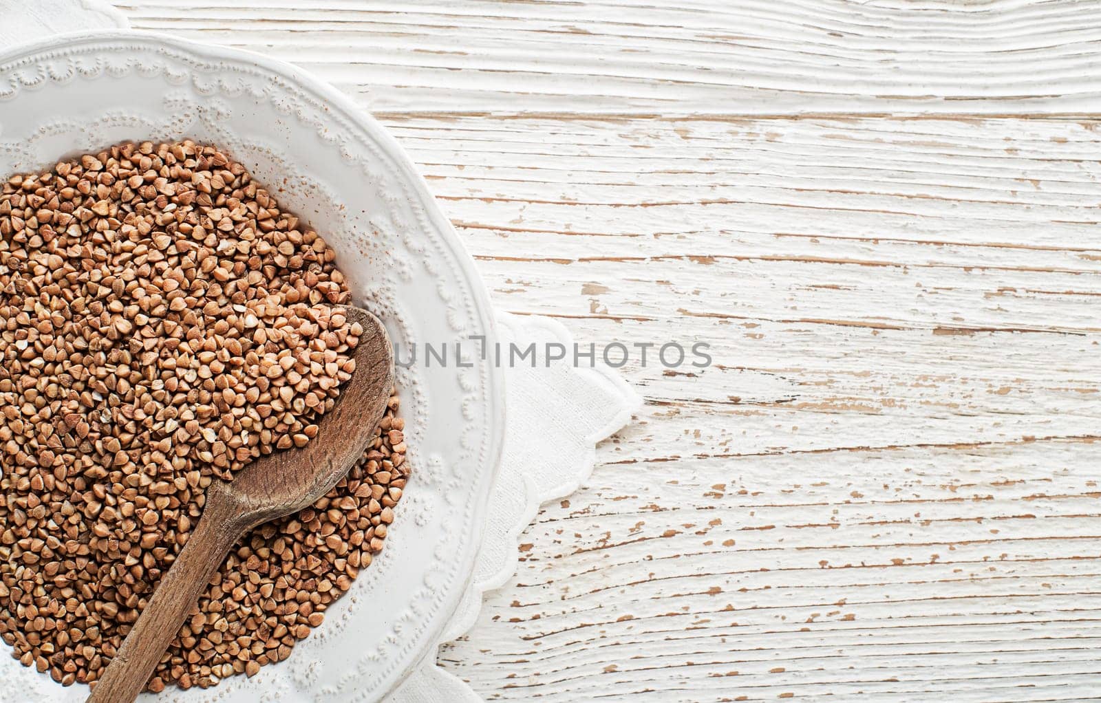 Healthy buckwheat cereal grains with spoon close up.