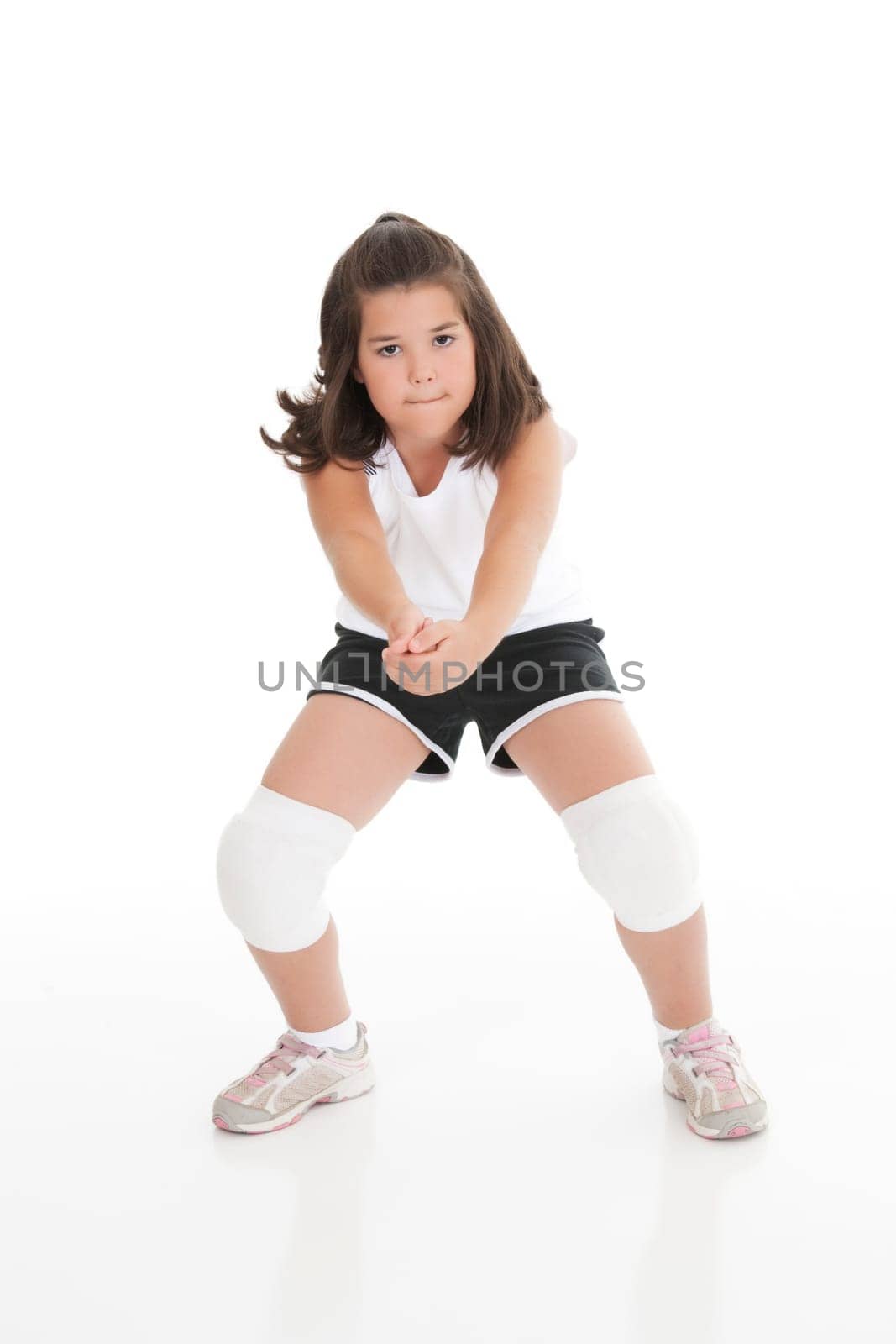 Cute Caucasian girl hitting the ball in volleyball