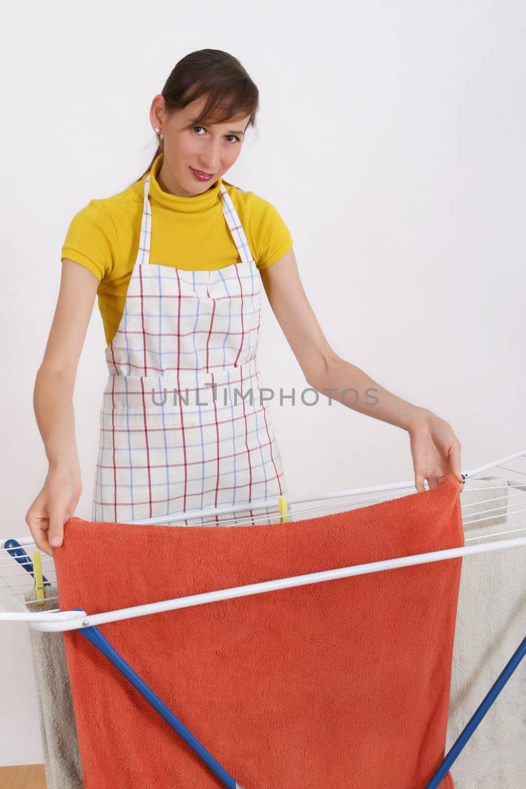 woman hanging towels on the rack, shot over white
