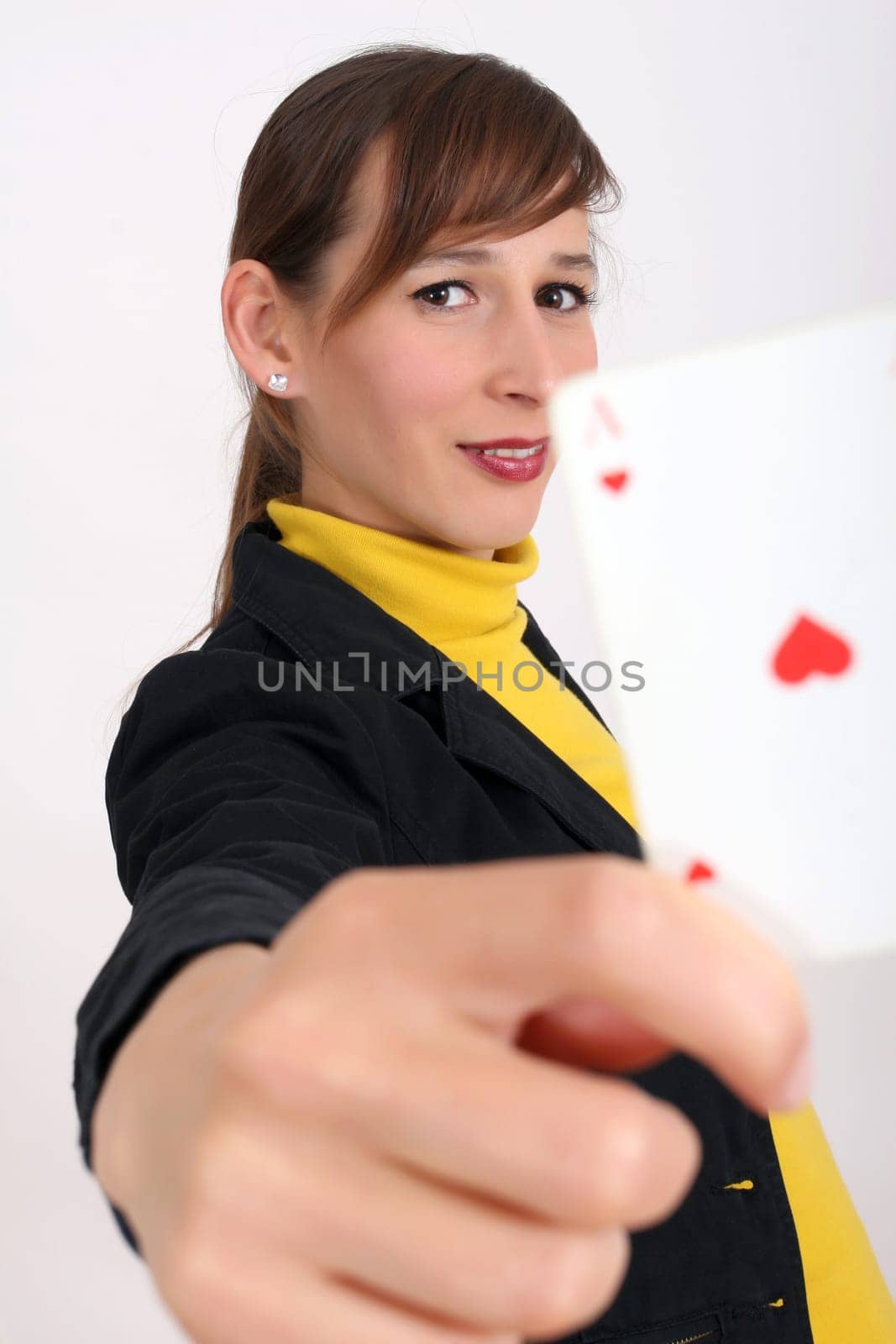 happy woman showing a playing card at the camera