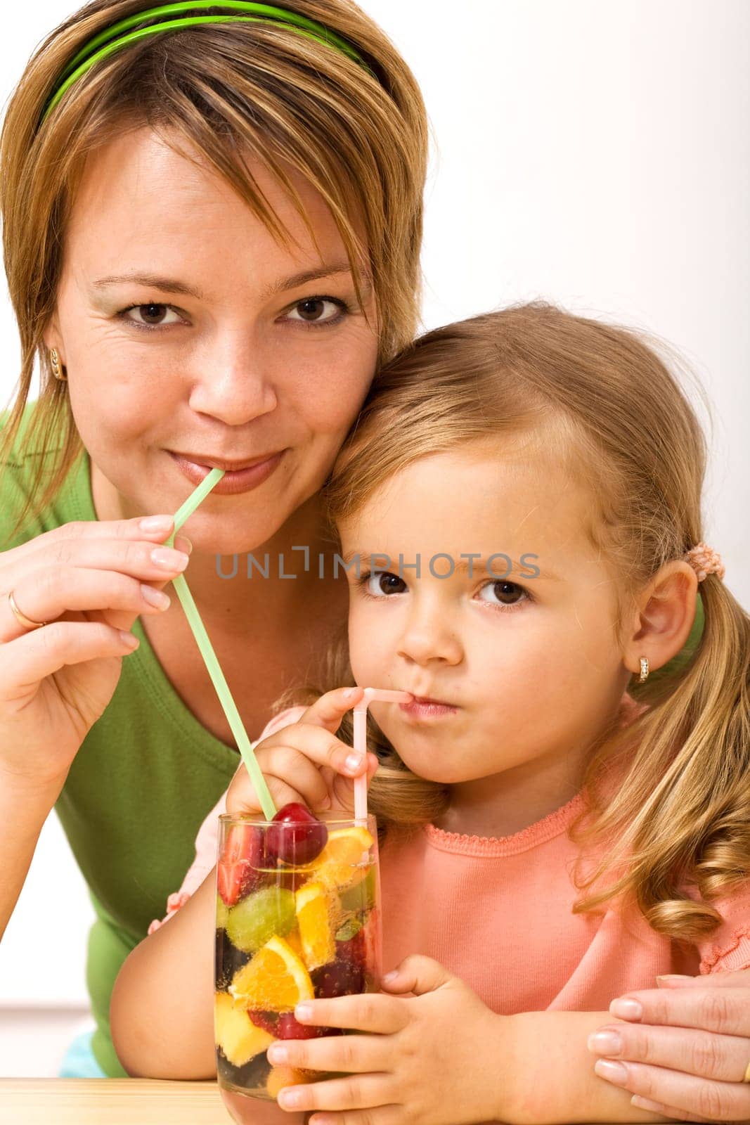 Woman and little girl sharing a fruity refreshment