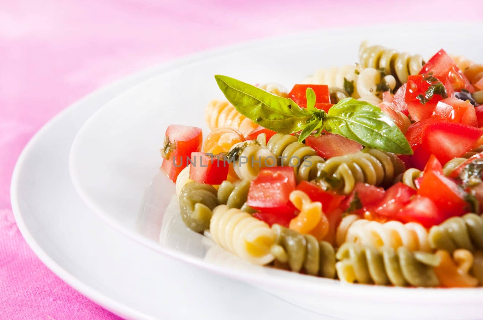 Pasta primavera garnished with basil leaves
