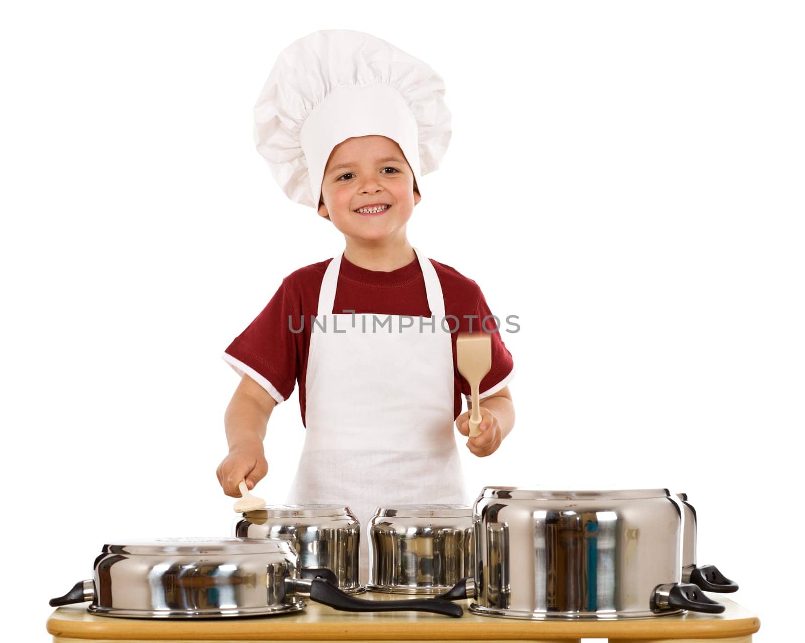 Feel the beat of culinary art - boy with wooden spoons making some noise banging cooking pots, isolated