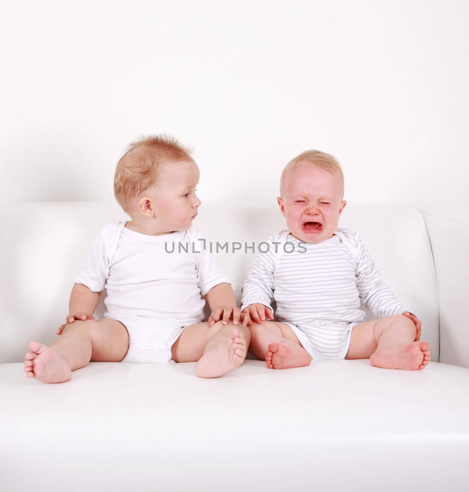 Two swert babies - one looking, one crying