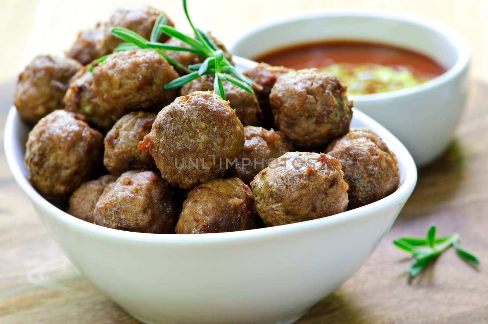 Fresh hot meatball appetizers served in white bowl with dipping sauce