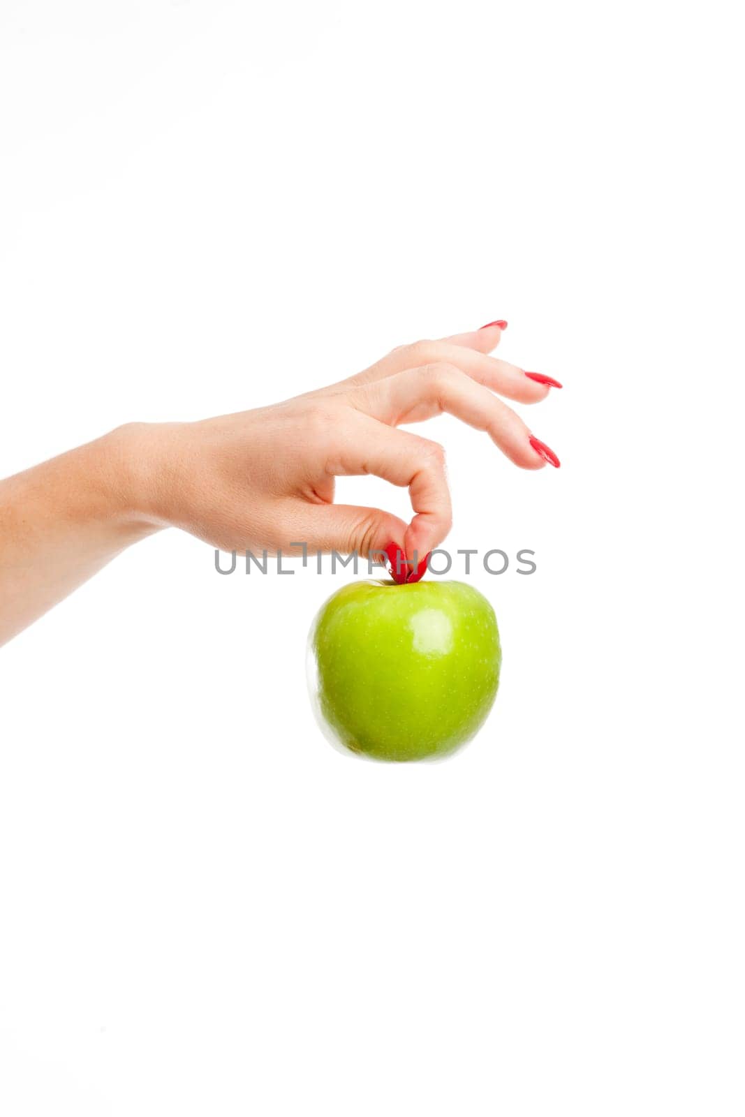 Woman hand holding a bright green apple by it's stalk