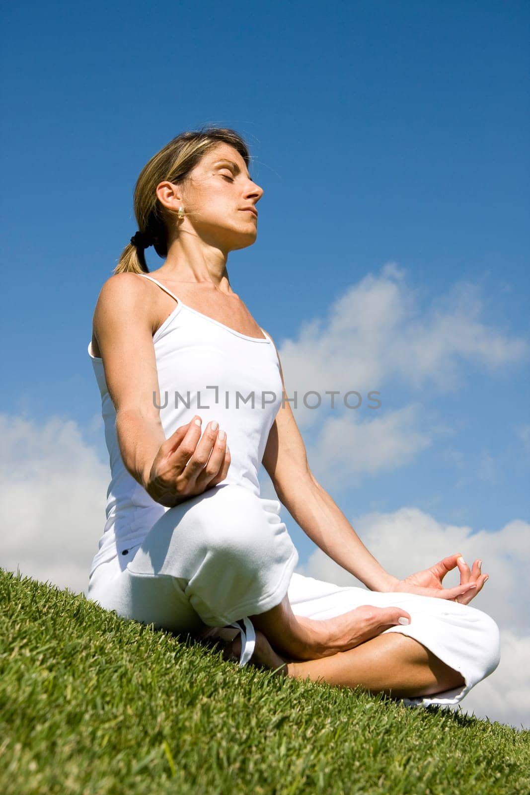 Pretty woman in white doing yoga outdoor