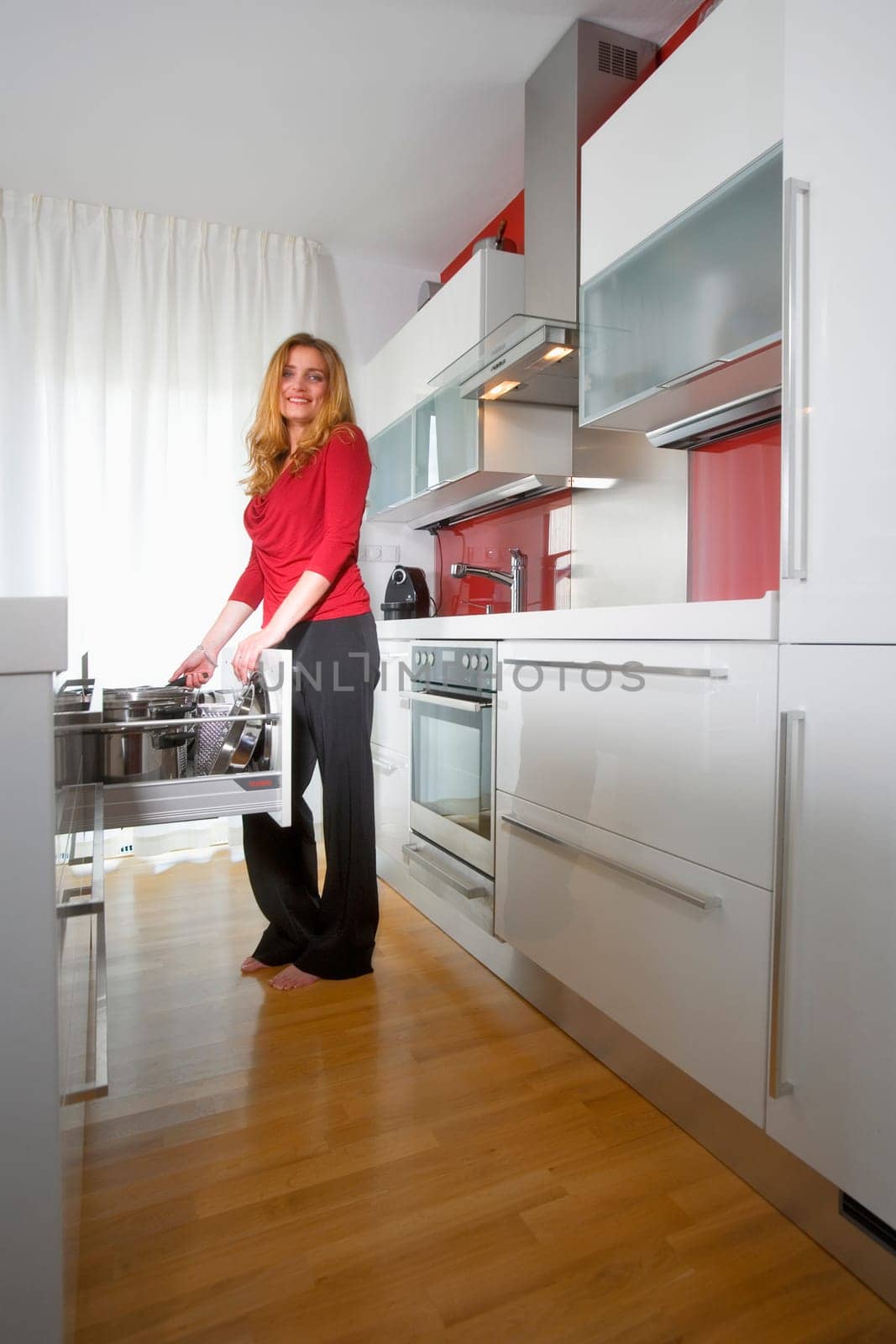 young beautiful woman standing in modern kitchen interior