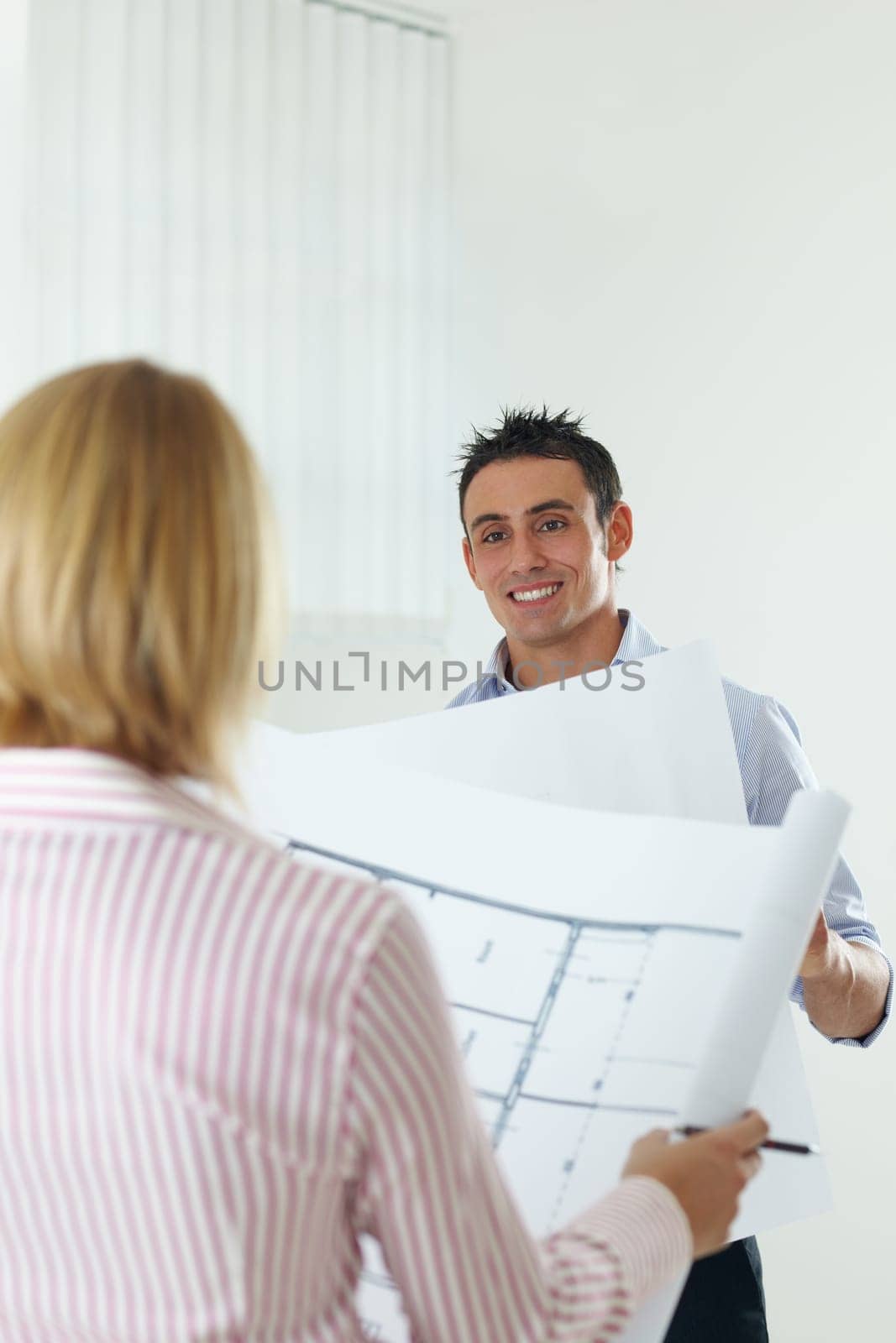 two architects examining blueprint indoors. Copy space