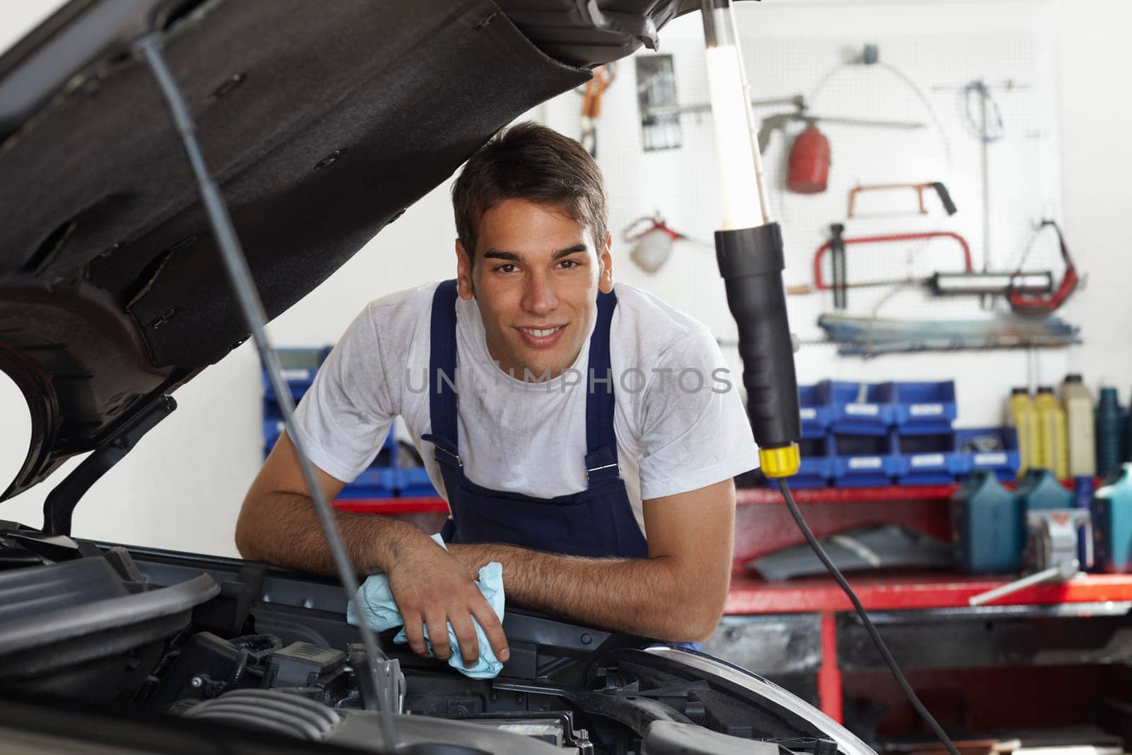 mechanic leaning on bonnet and looking at camera