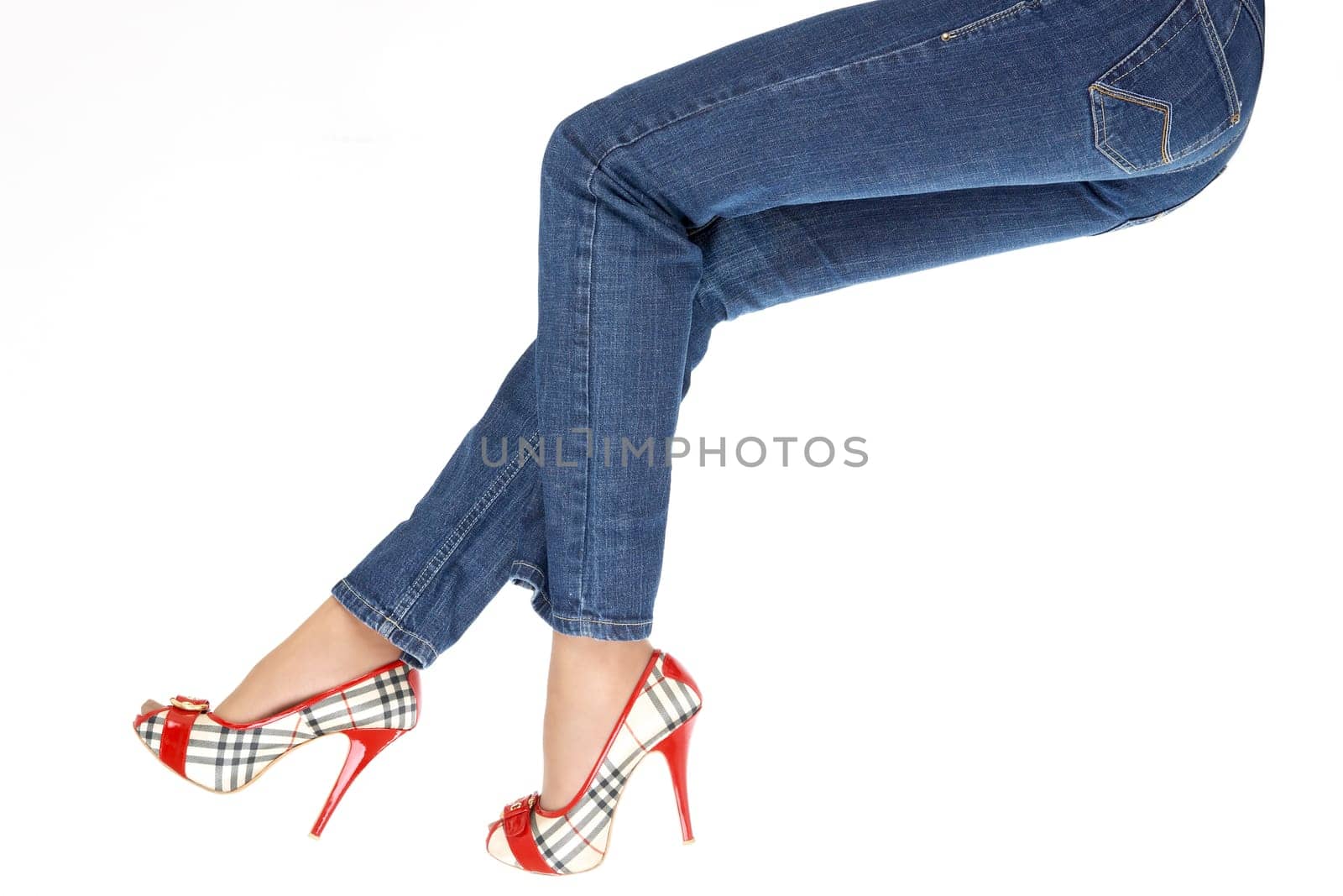 Close up of female legs in the dark blue jeans, isolated