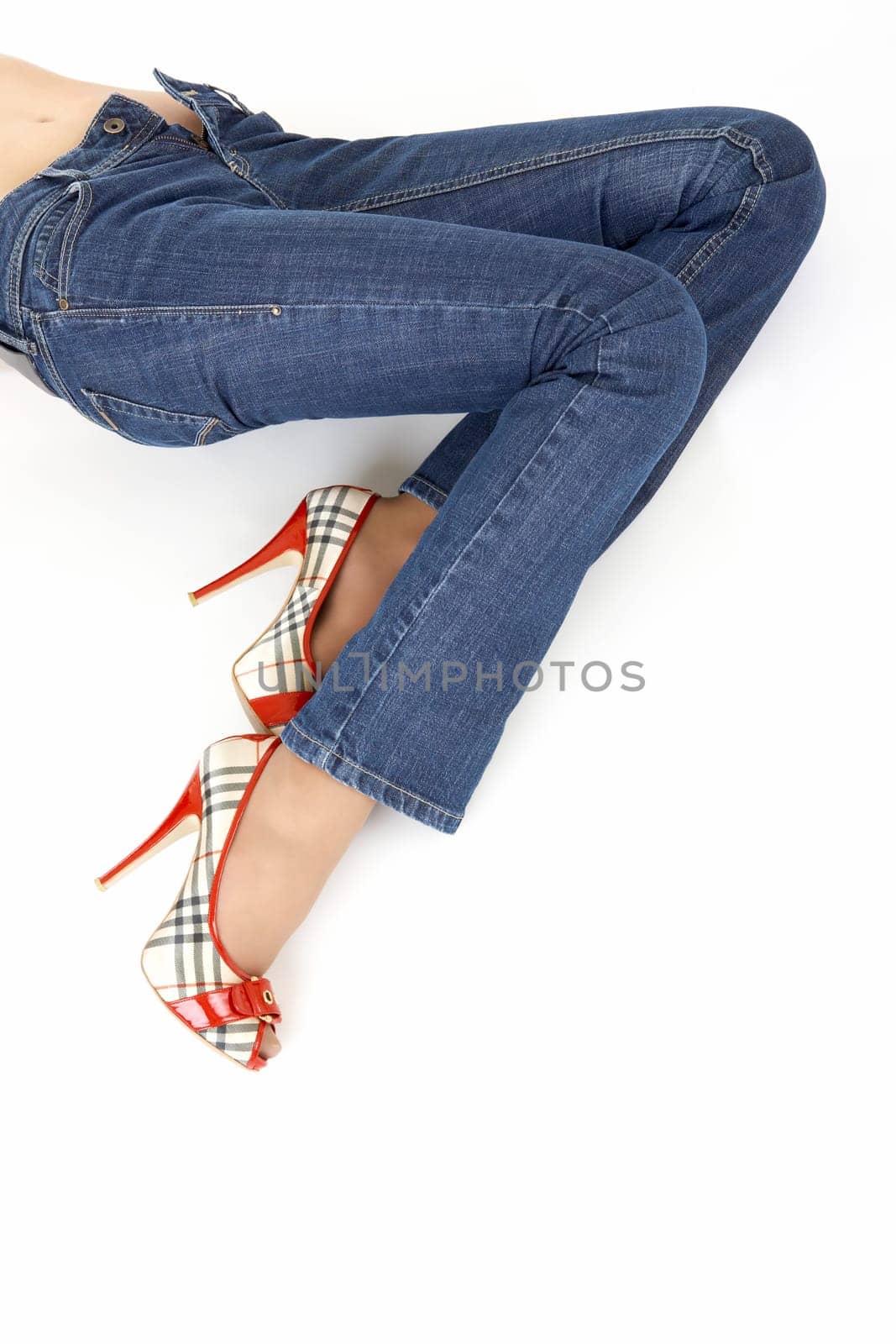 Lying female legs in the jeans trousers, isolated