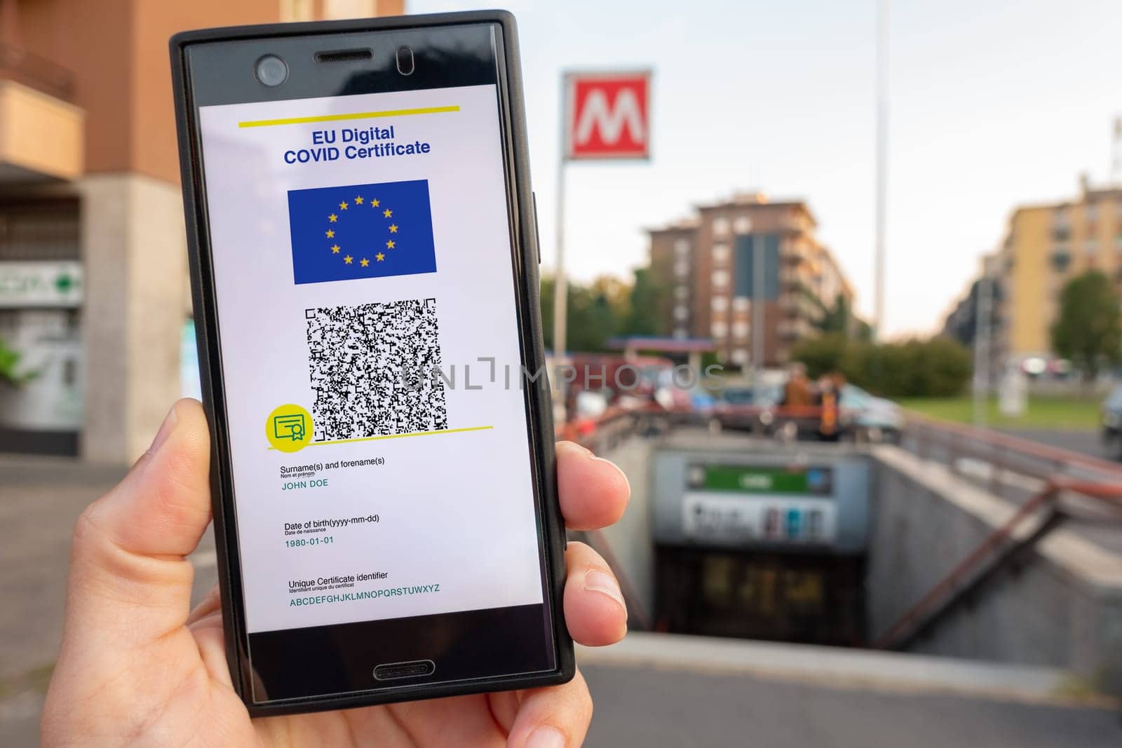 Woman showing on smartphone EU Digital Covid Certificate Green Pass with quad code. Underground background.