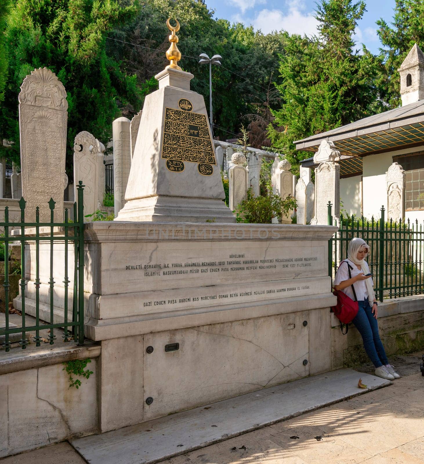Istanbul, Turkey - September 1 2022: Woman standing beside Grave of Ghazi Edhem Pasha, or Gazi Ethem Pasa, located in Eyup Sultan Mosque courtyard burial, Eyup district