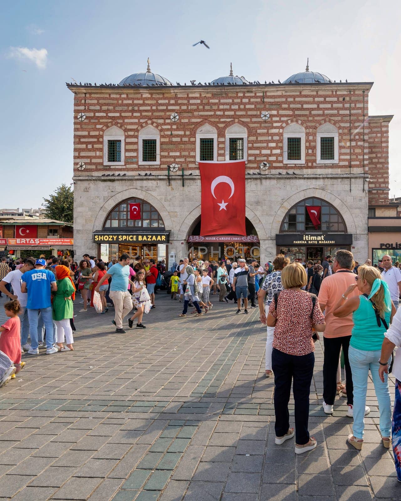 Istanbul, Turkey - August 30, 2022: Crowds of local citizens at Eminonu during the Victory Day holiday with entrance of The Spice Bazaar, aka Misir Carsisi, or Egyptian Bazaar in the background