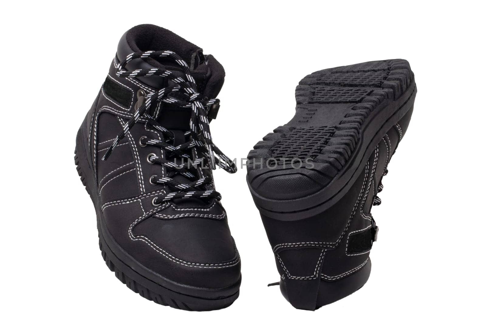 Winter boots. Close-up of a pair elegant black leather winter boots with laces and rivets isolated on white. Macro. Autumn shoe fashion for child boy.