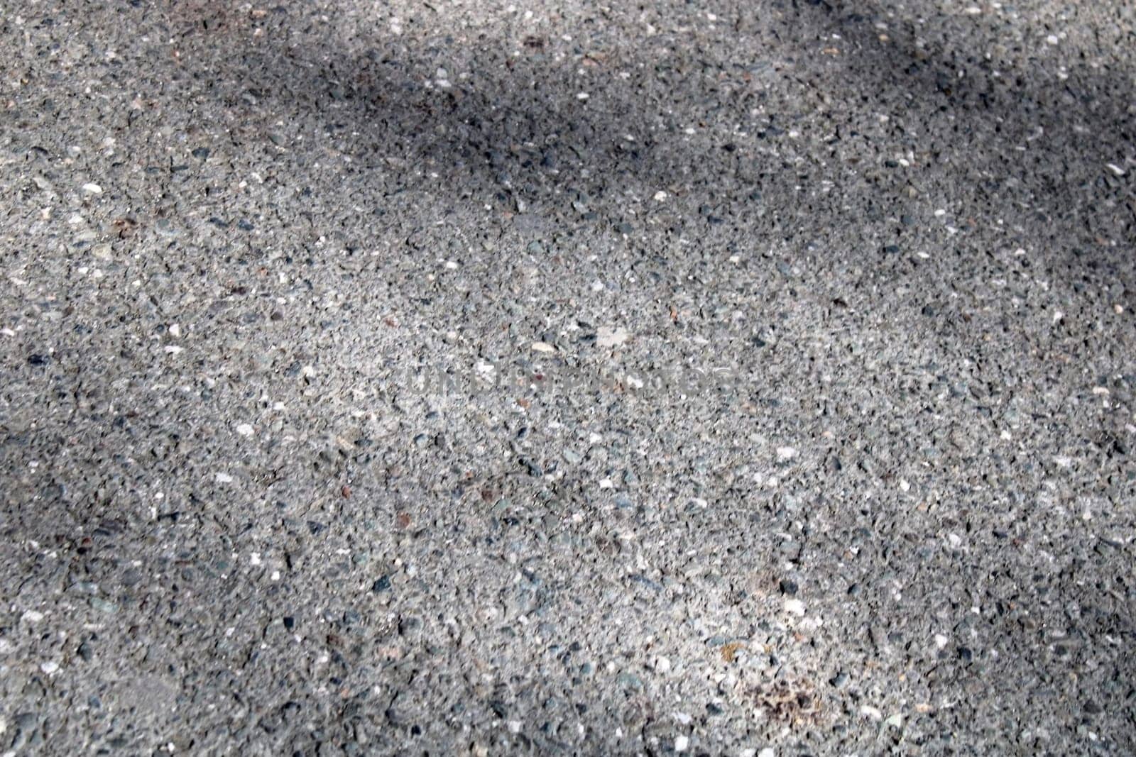 A light wall of stone chips with a shadow falling on it. The texture of the stone. Universal natural background.