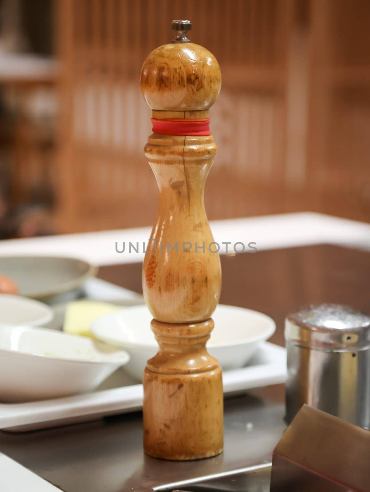 A salt or pepper mill is ready next to the stove in the kitchen.