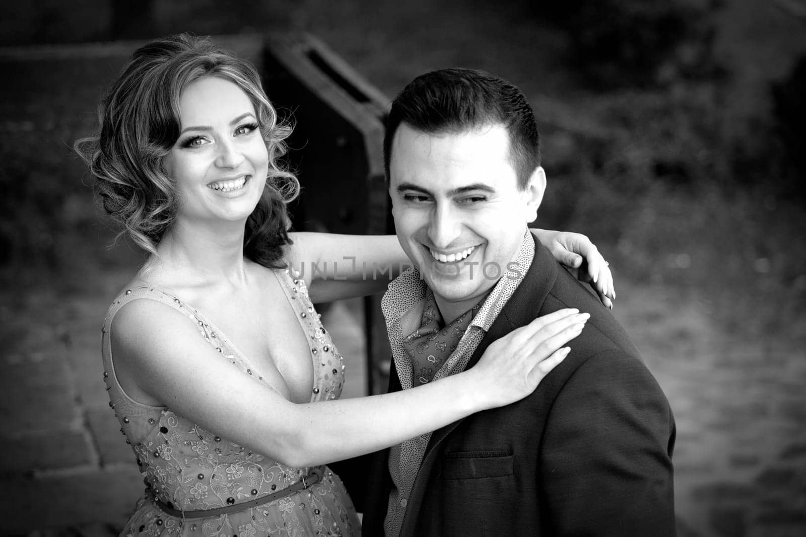 Newly wed couple laughing outdoor on a summer day.