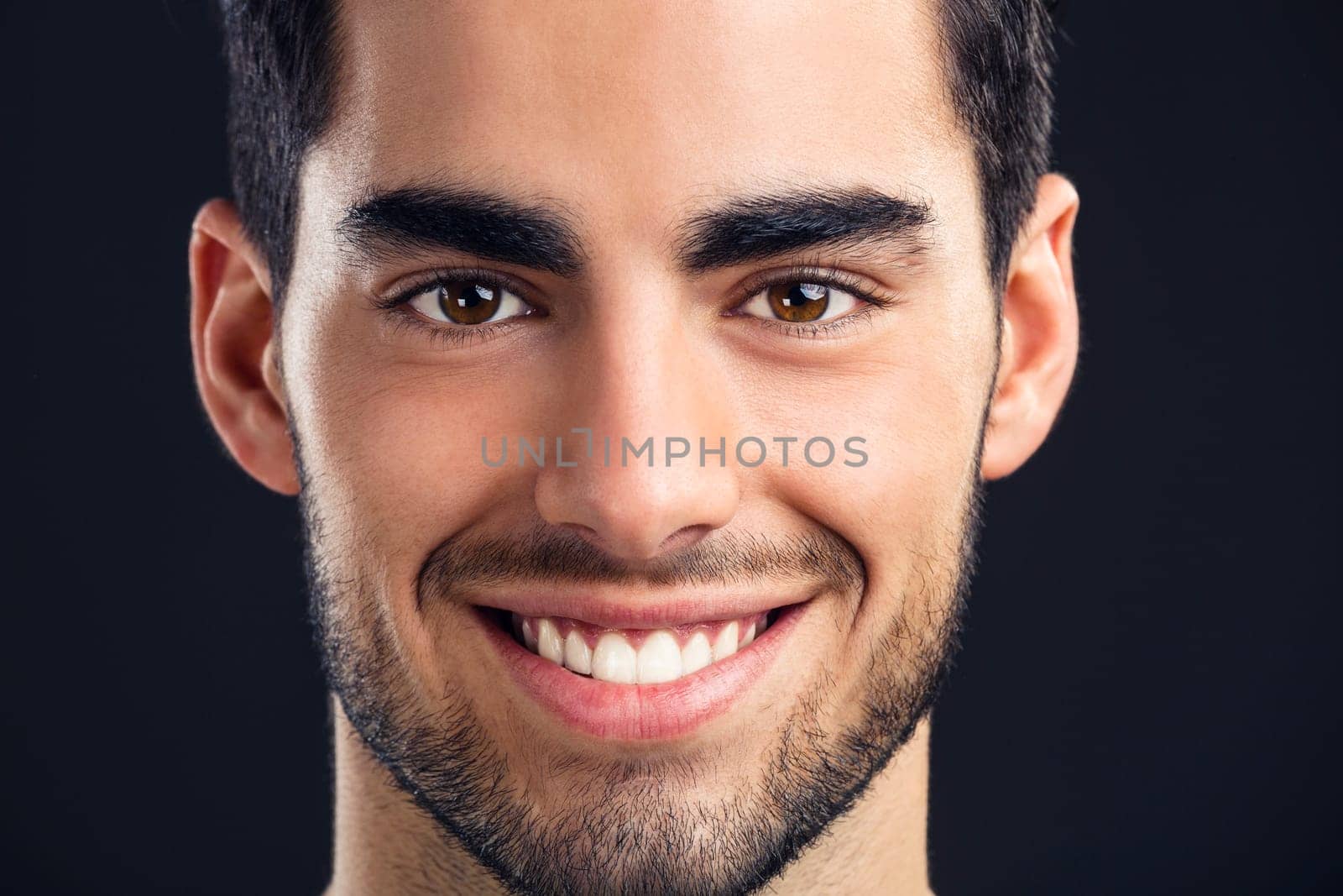 Portrait of handsome young man smiling, isolated on gray background