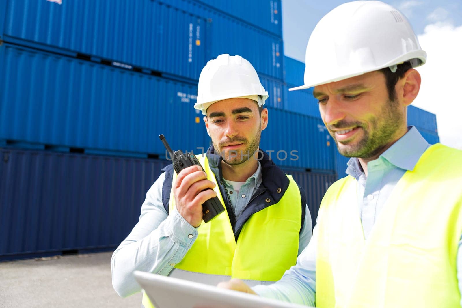 View of a Dock worker and supervisor checking containers data on tablet