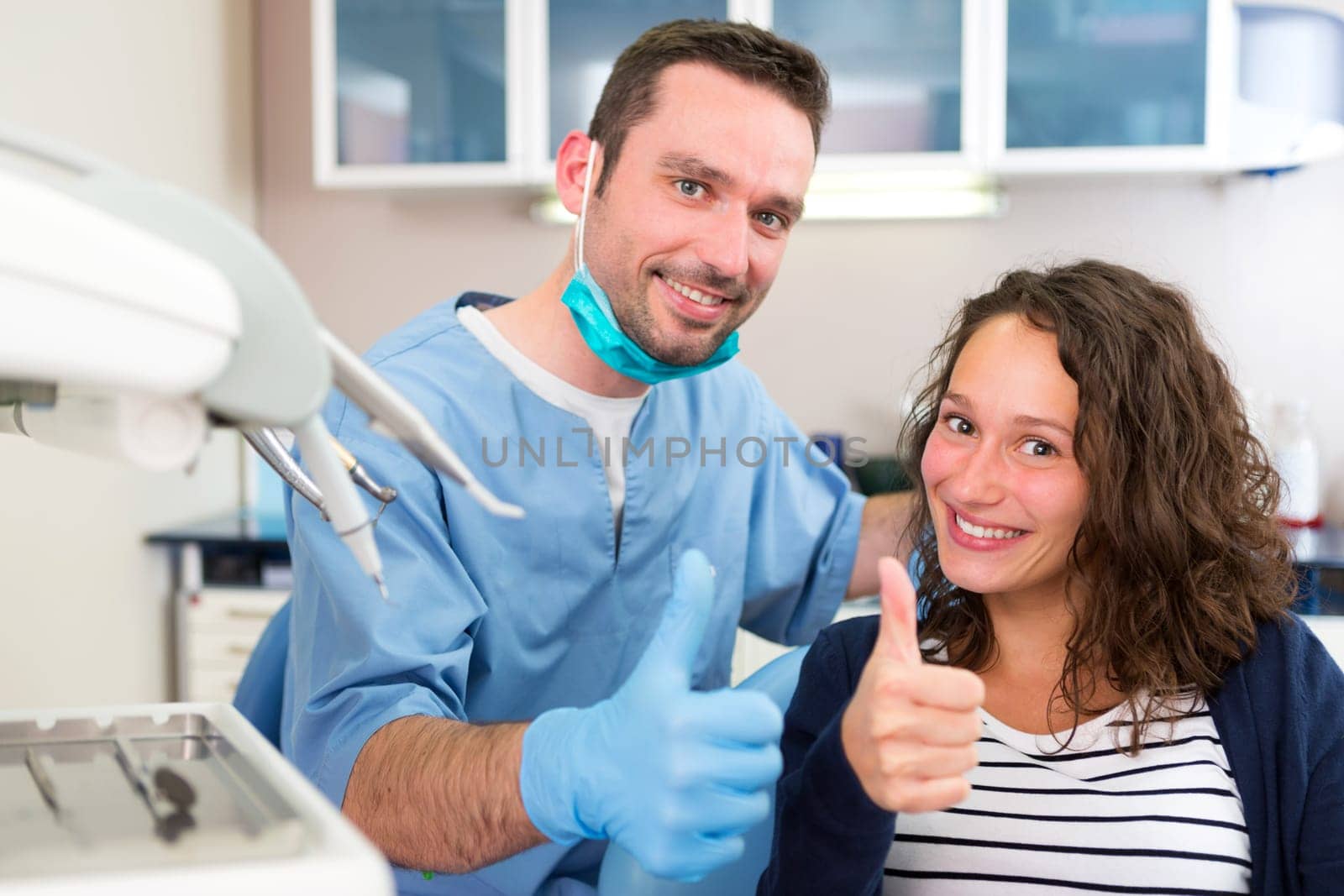 View of a Young attractive dentist explaning his work to a patient