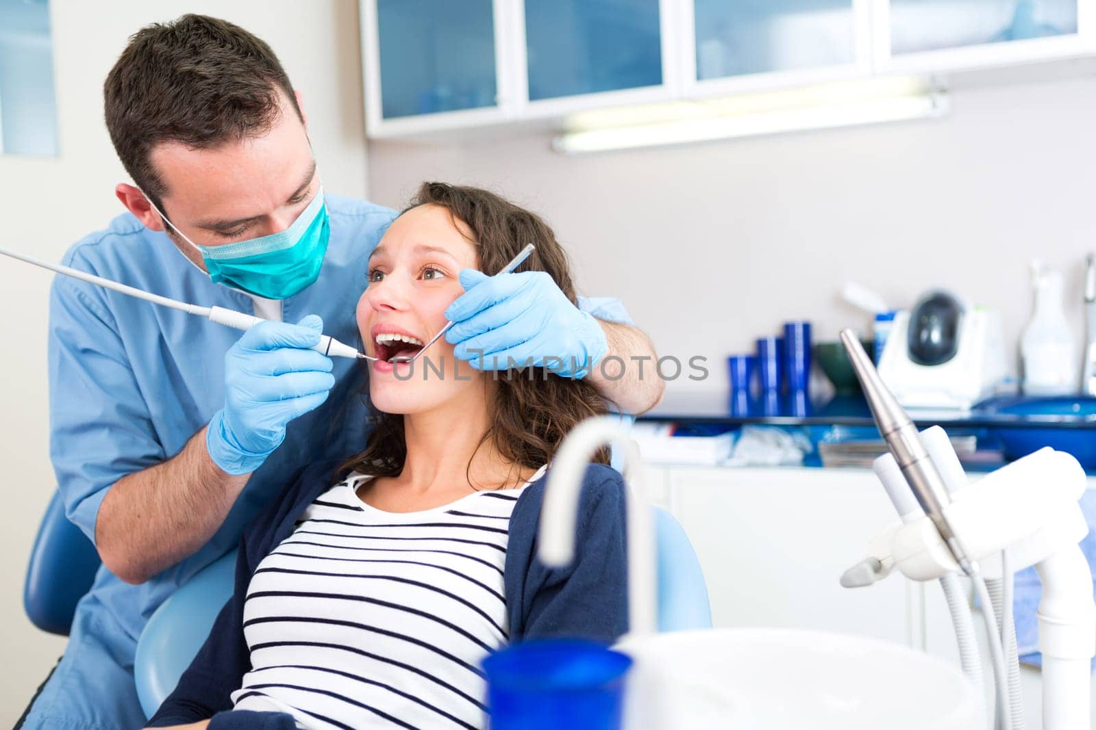 View of a Young attractive woman being cured by a dentist
