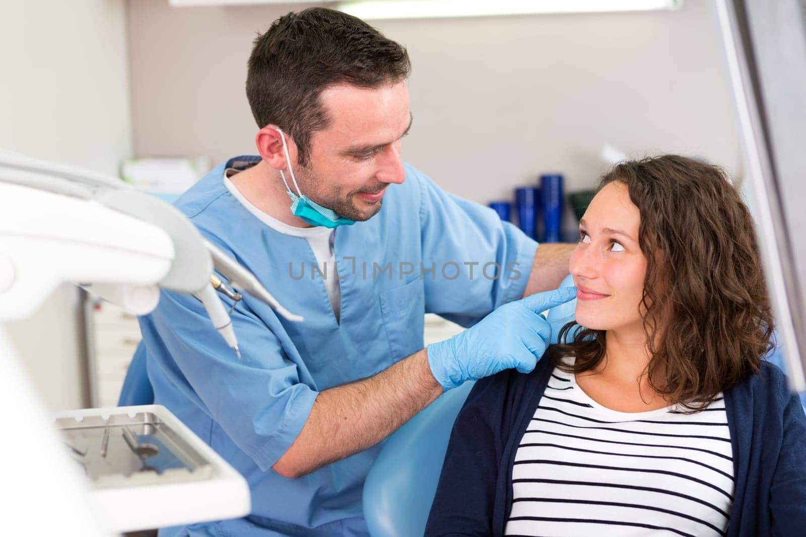 View of a Young attractive dentist explaning his work to a patient