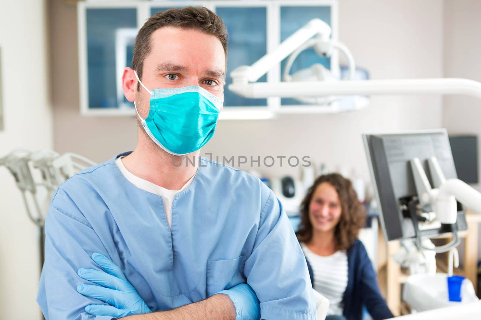 View of a young attractive dentist in his office