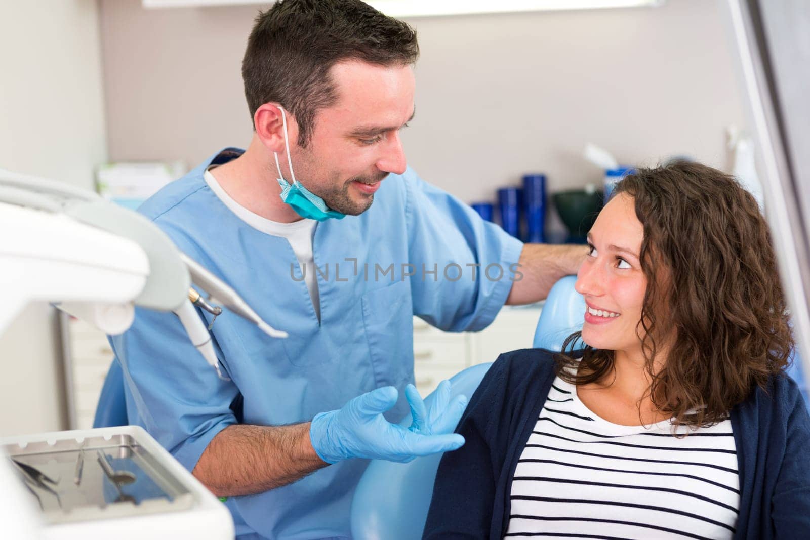 View of a Young attractive dentist explaning his work to a patient