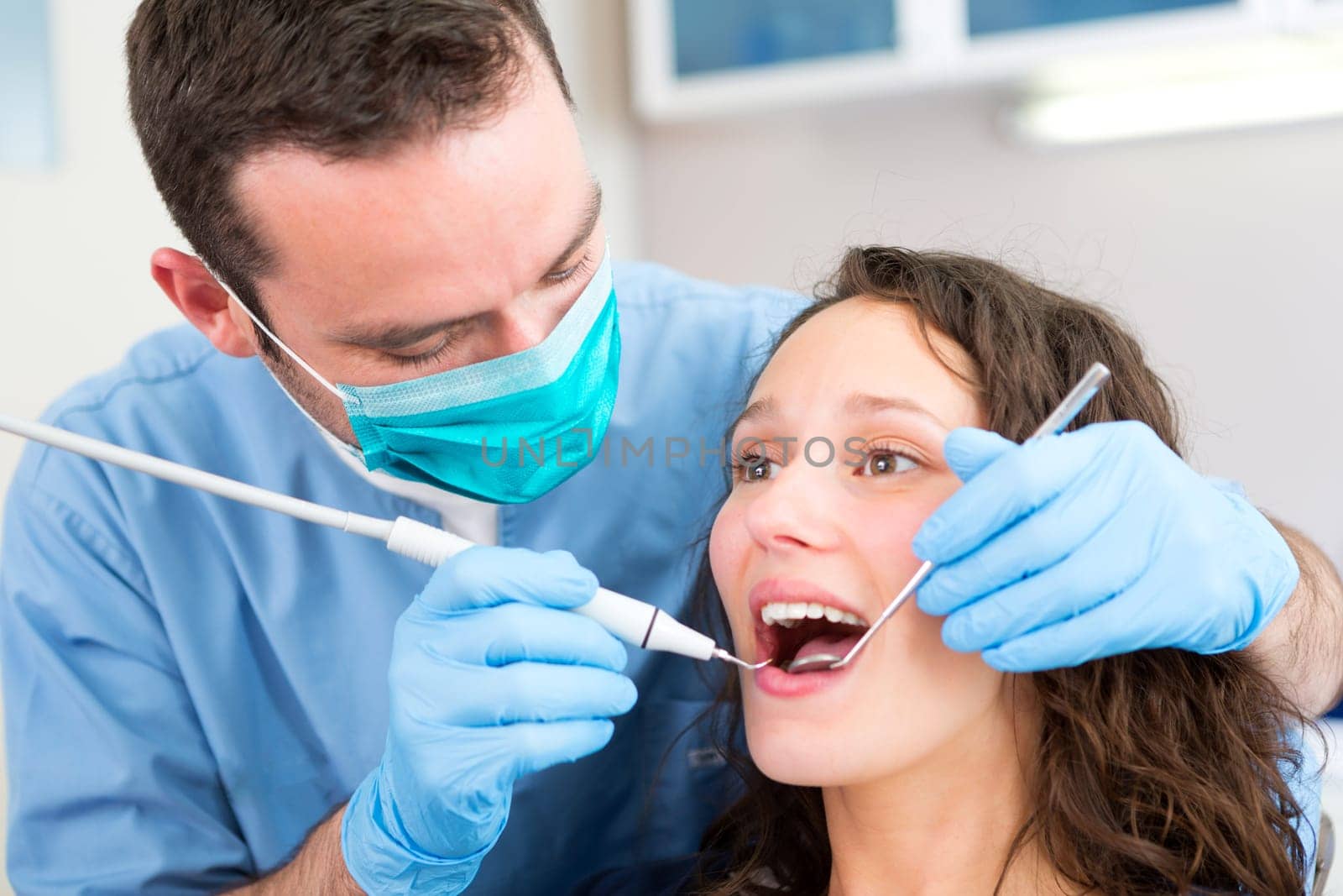 View of a Young attractive woman being cured by a dentist