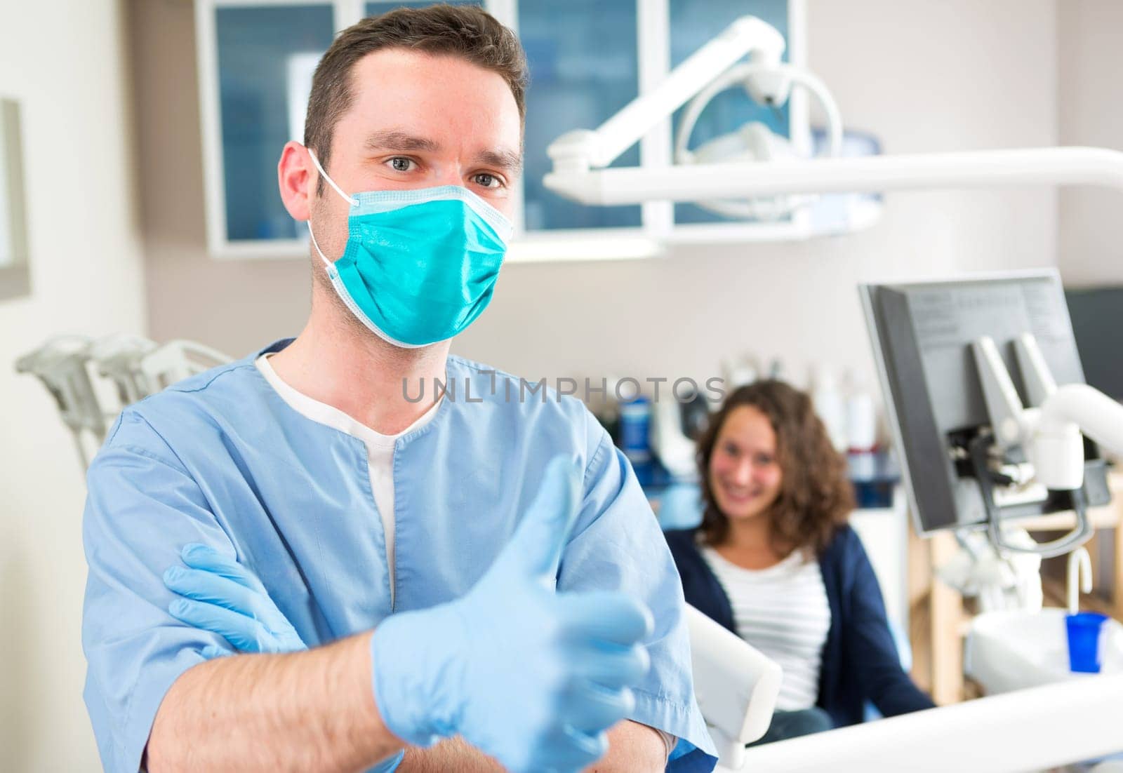 View of a young attractive dentist in his office