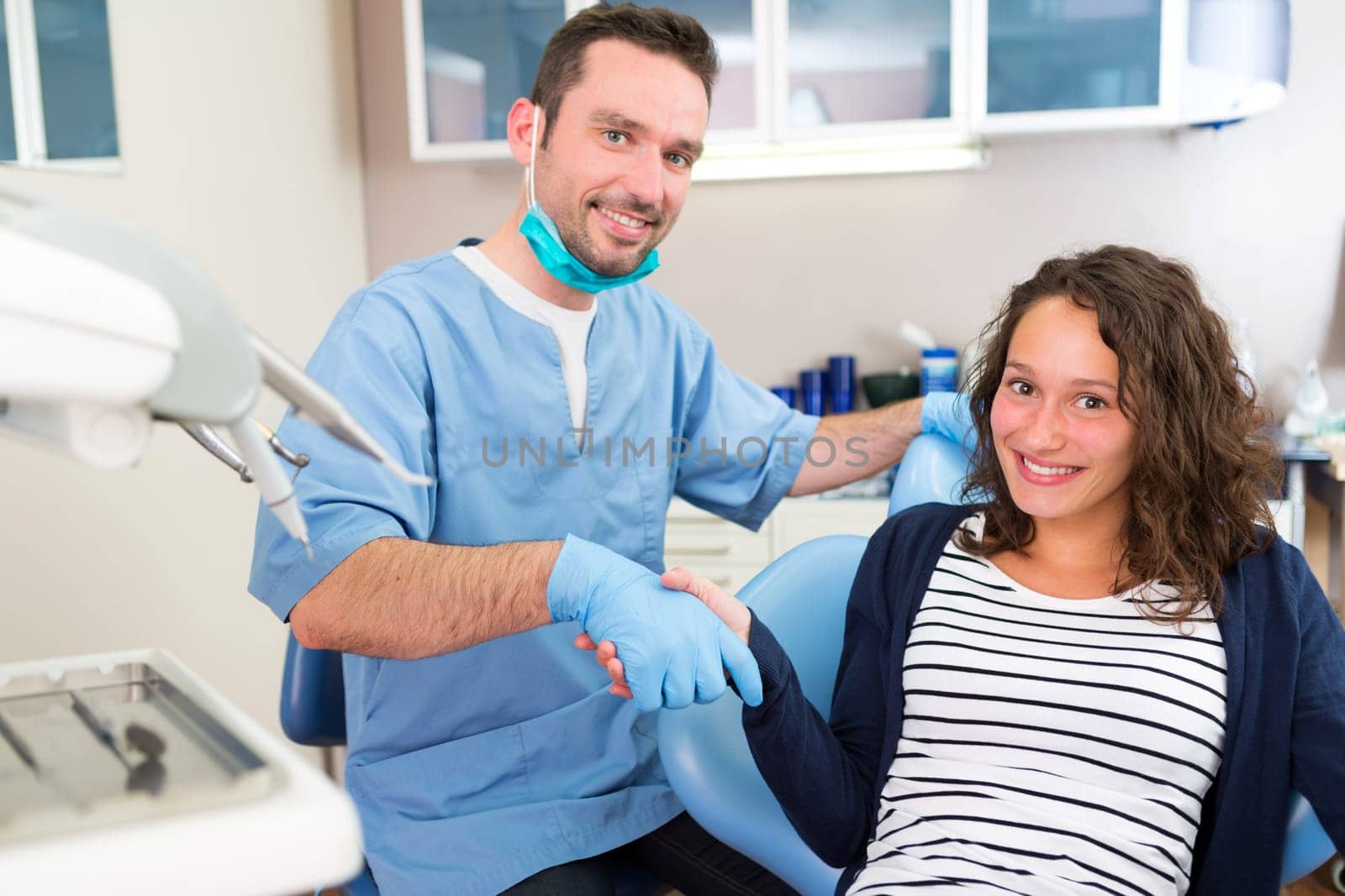 View of a Young attractive dentist explaning his work to a patient