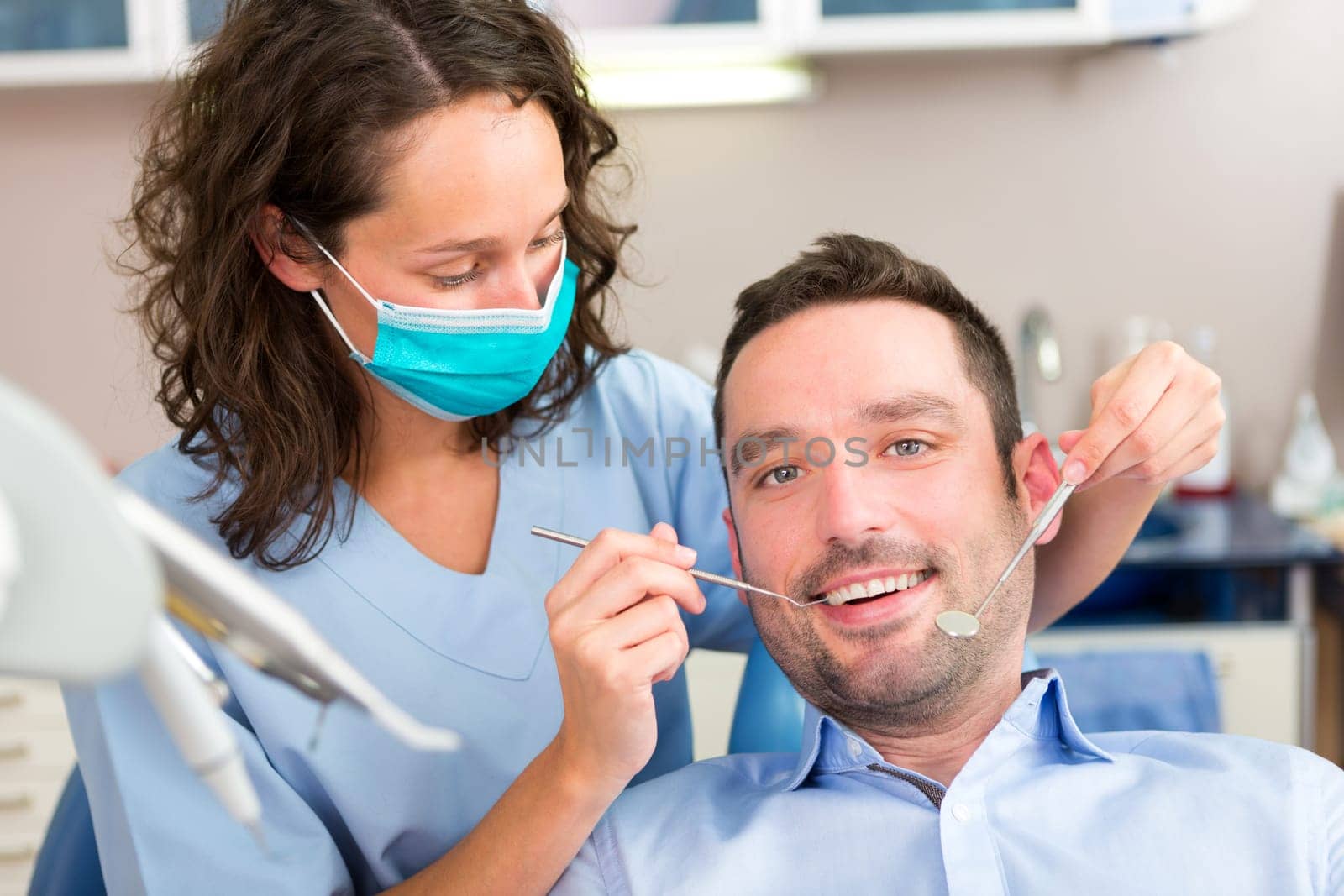 View of a Young attractive man being cured by a dentist