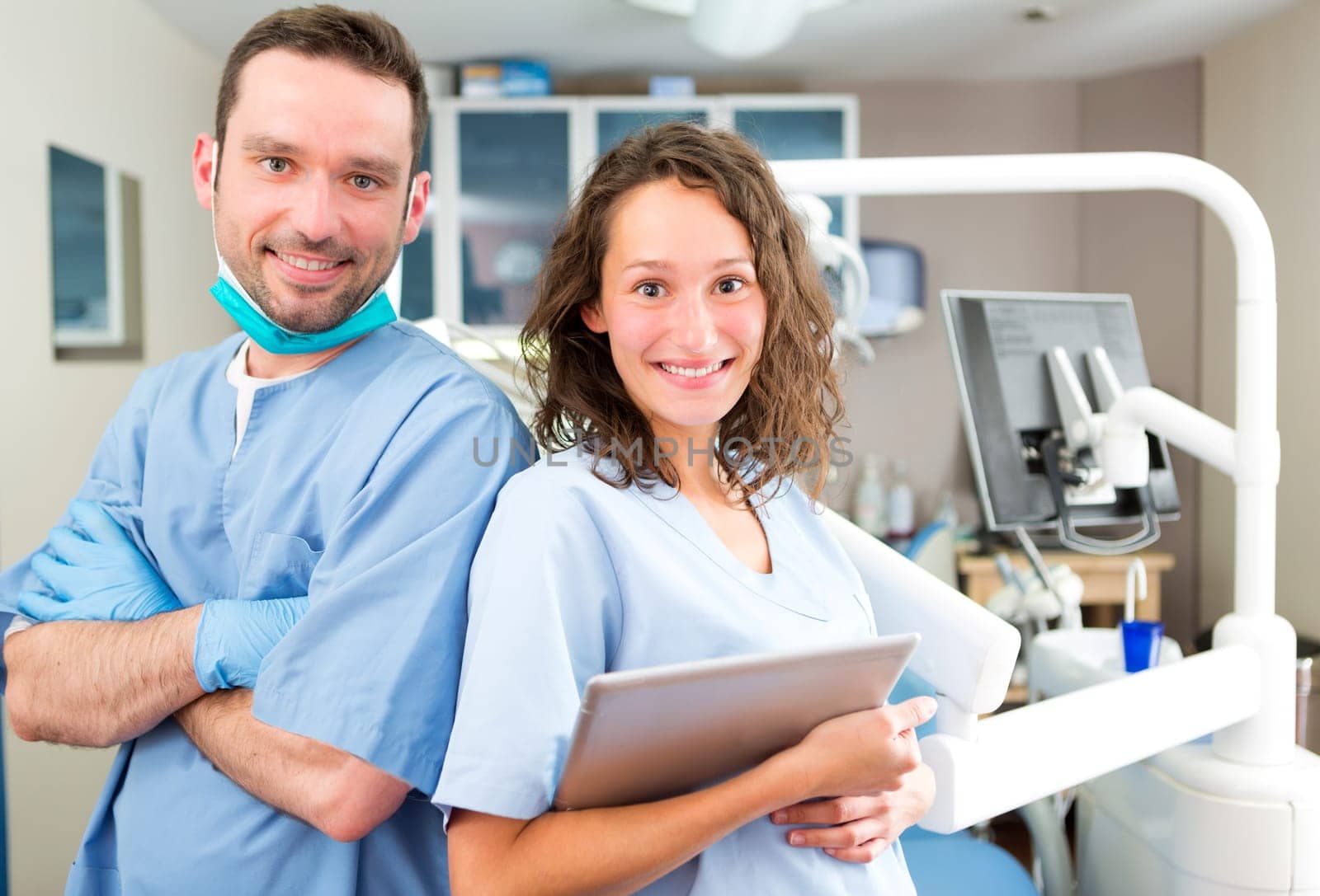 View of a Portrait of a young attractive dentist and his assistant in his office