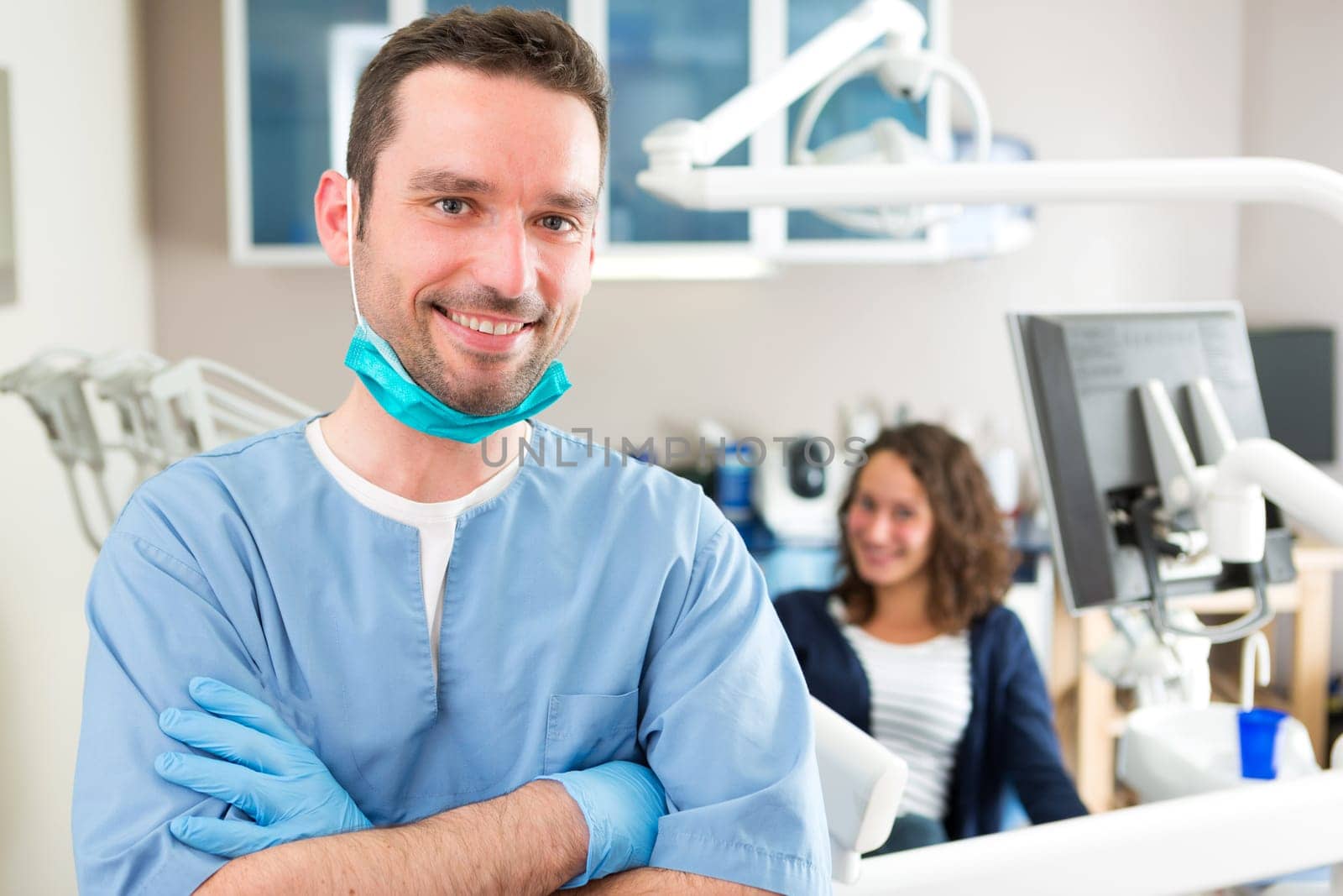 View of a young attractive dentist in his office