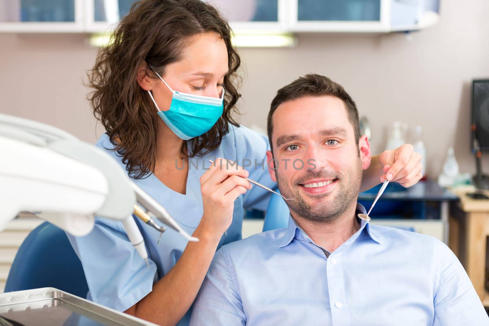 View of a Young attractive man being cured by a dentist