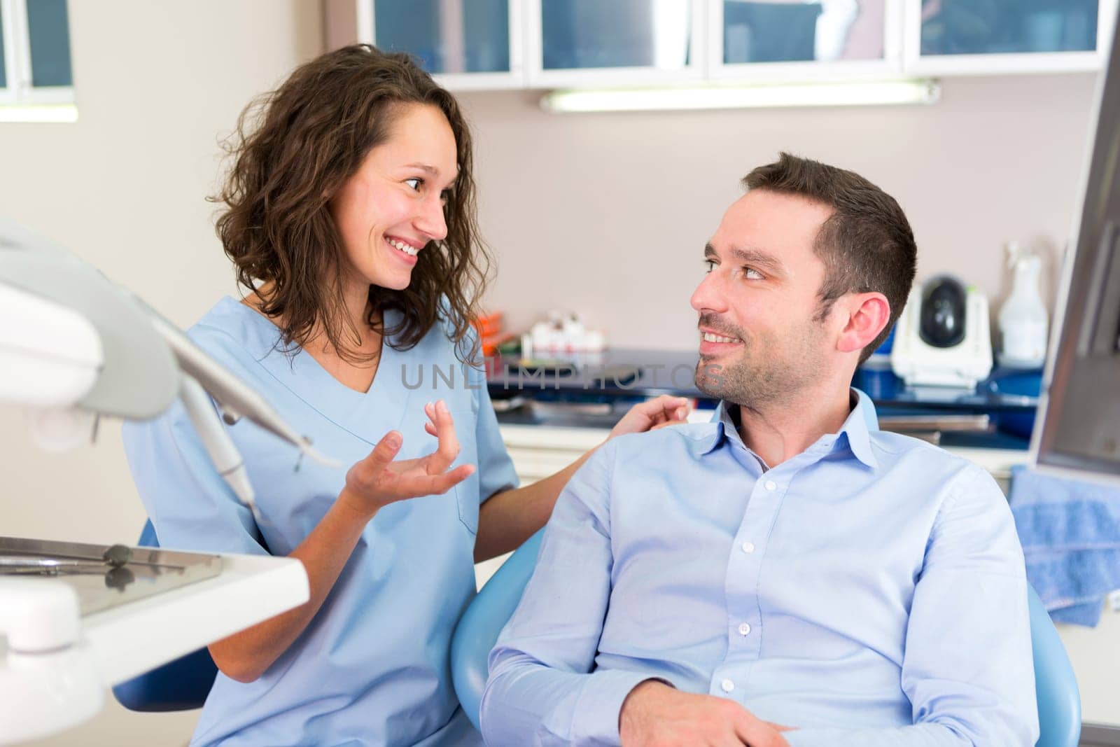 View of a Young attractive dentist explaning his work to a patient