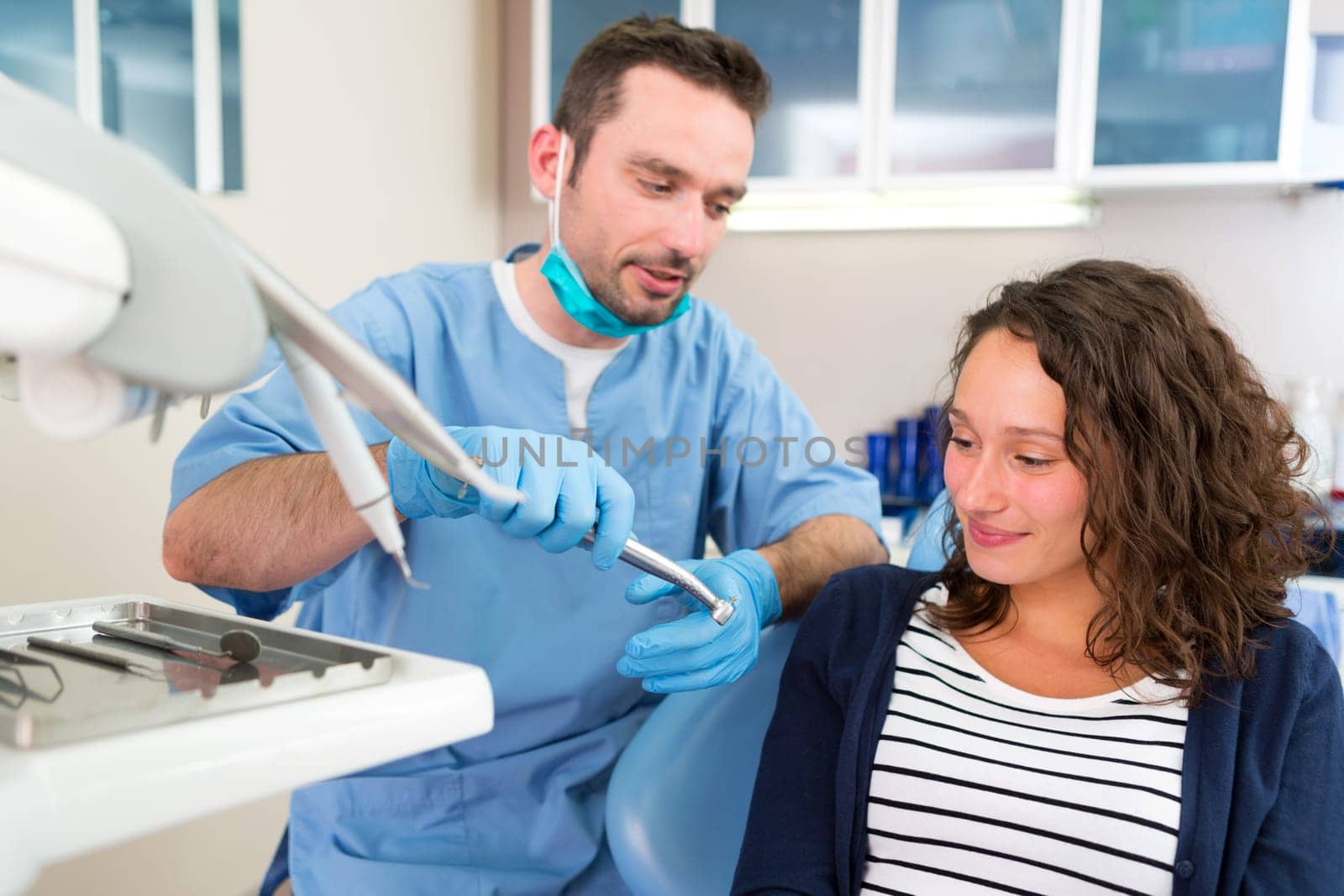 View of a Young attractive dentist explaning his work to a patient