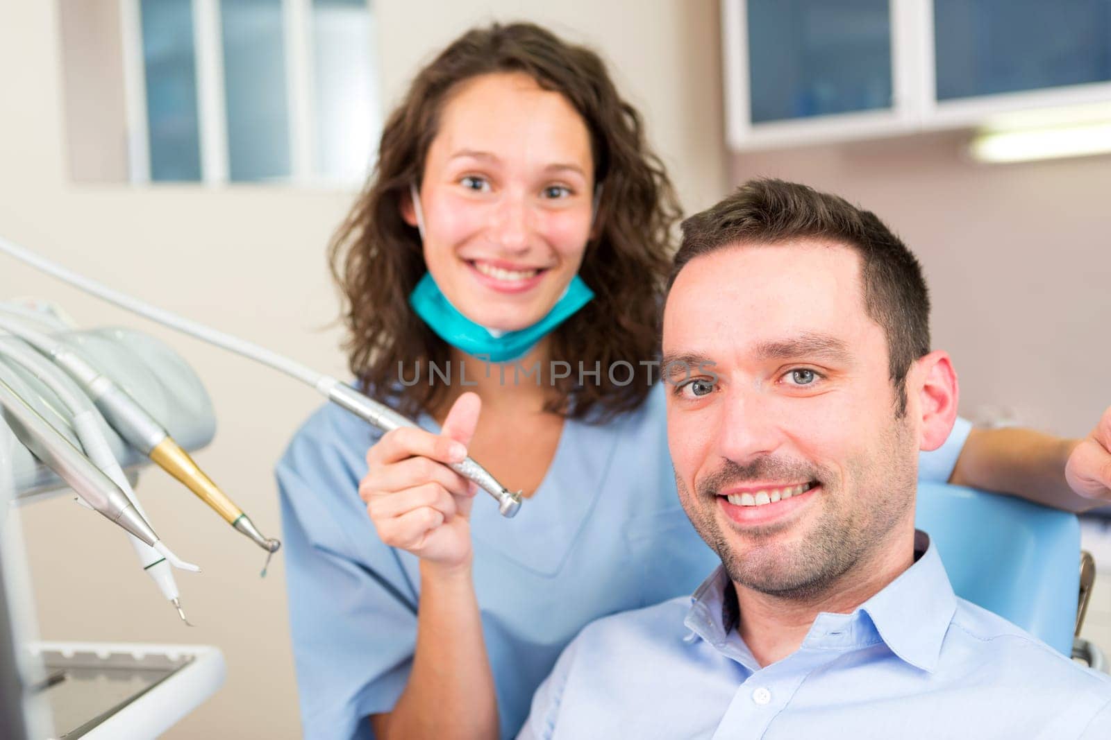 VIew of a Portrait of a young attractive dentist in his office with patient