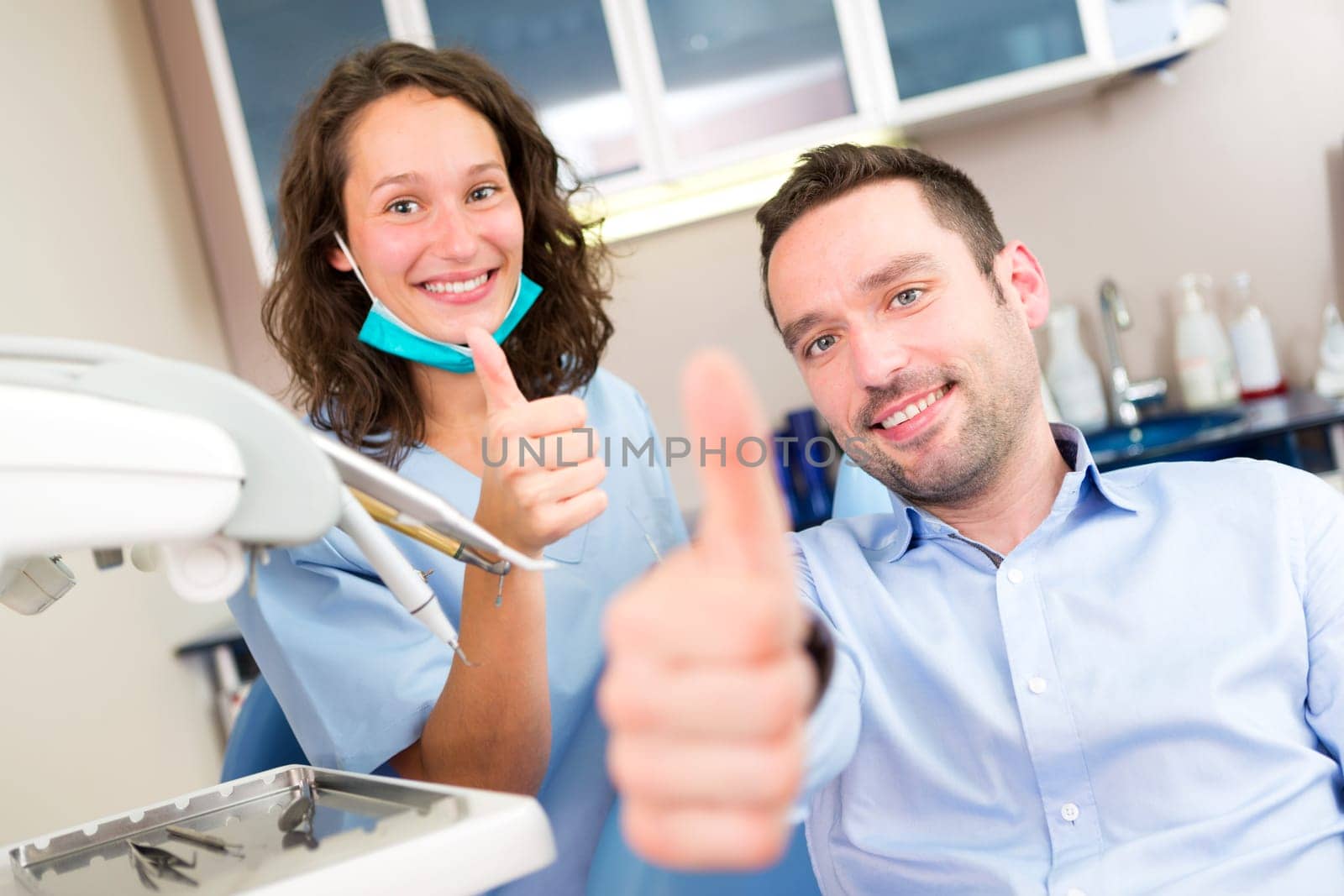 VIew of a Portrait of a young attractive dentist in his office with patient