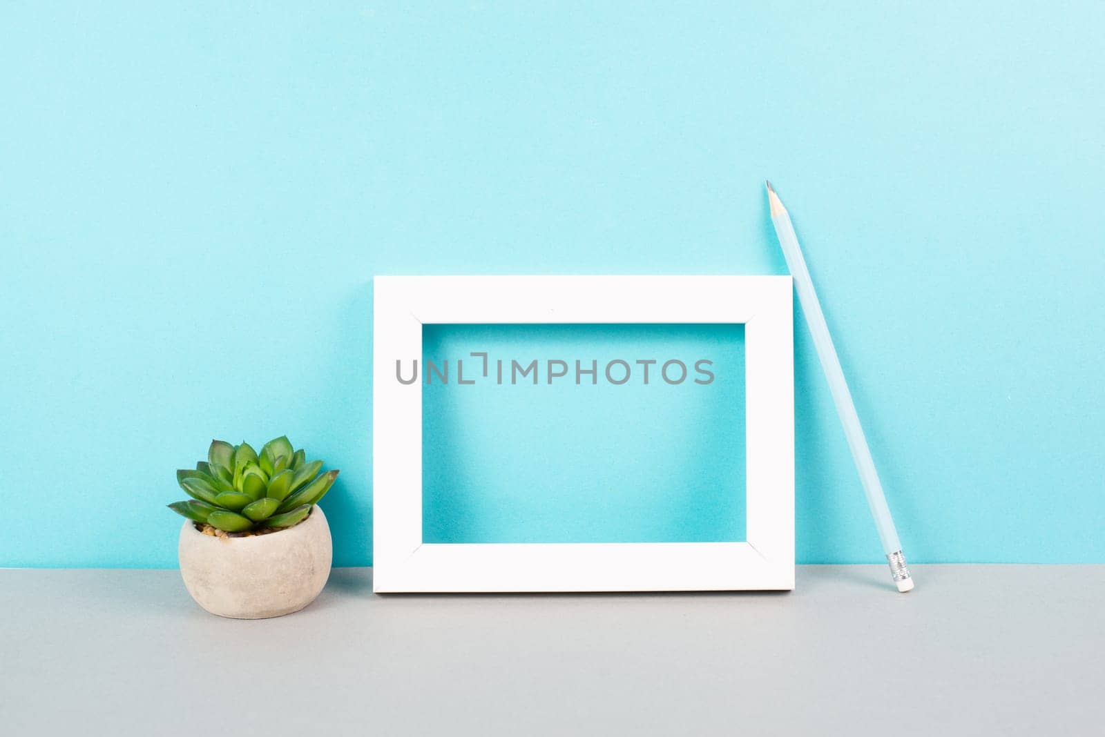 Home interior poster mock up with wooden frame, cactus in a pot, blue wall background, copy space for text and pictures