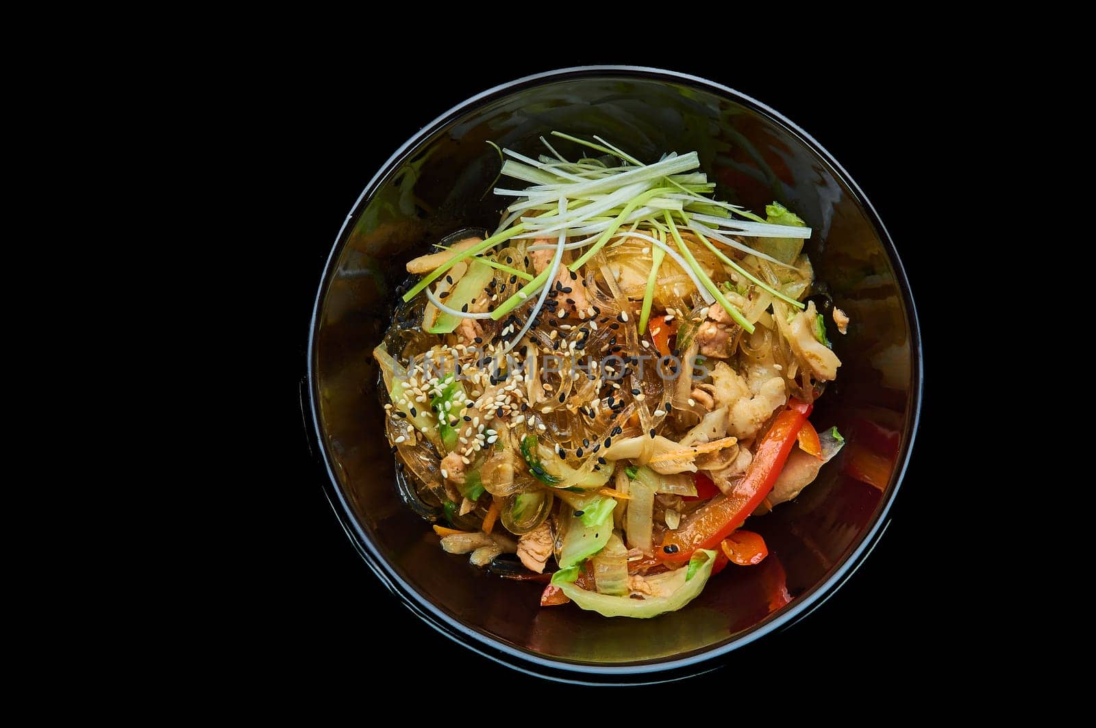 Harusame noodles with seafood in a deep bowl on a black isolated background. High quality photo