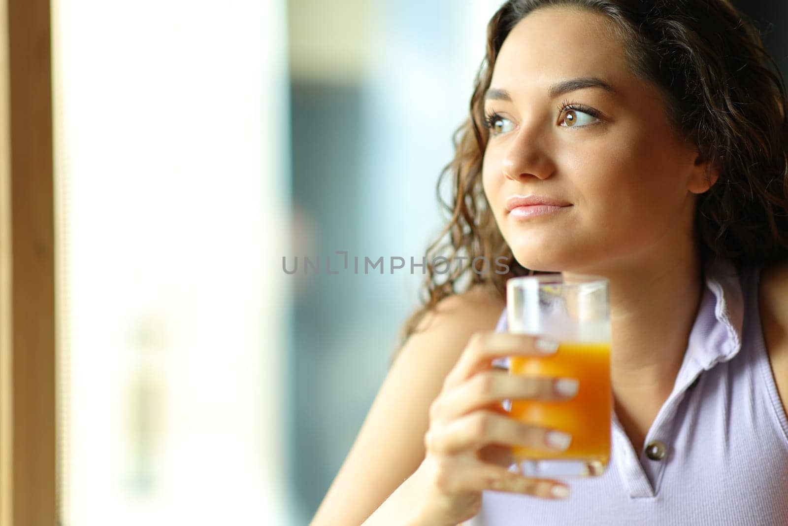 Beautiful woman holding orange juice at breakfast
