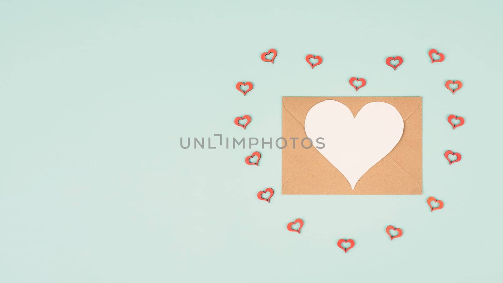 Valentine day greeting card, envelope with hearts on pastel background, love symbol, flat lay