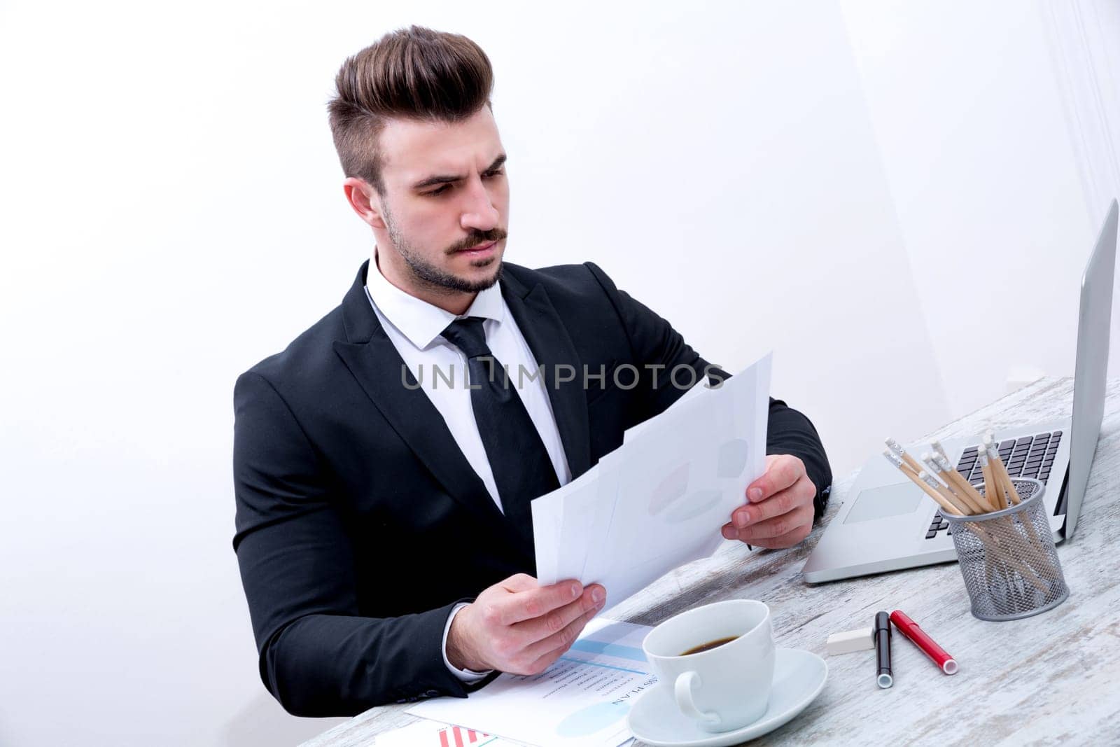 Working at the office with the laptop and some documents.