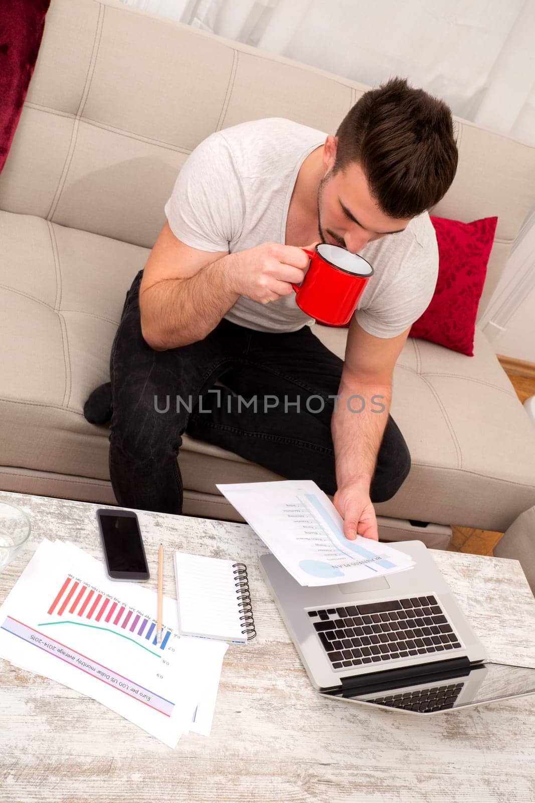 Businessman working at home in the laptop and drinking coffee.