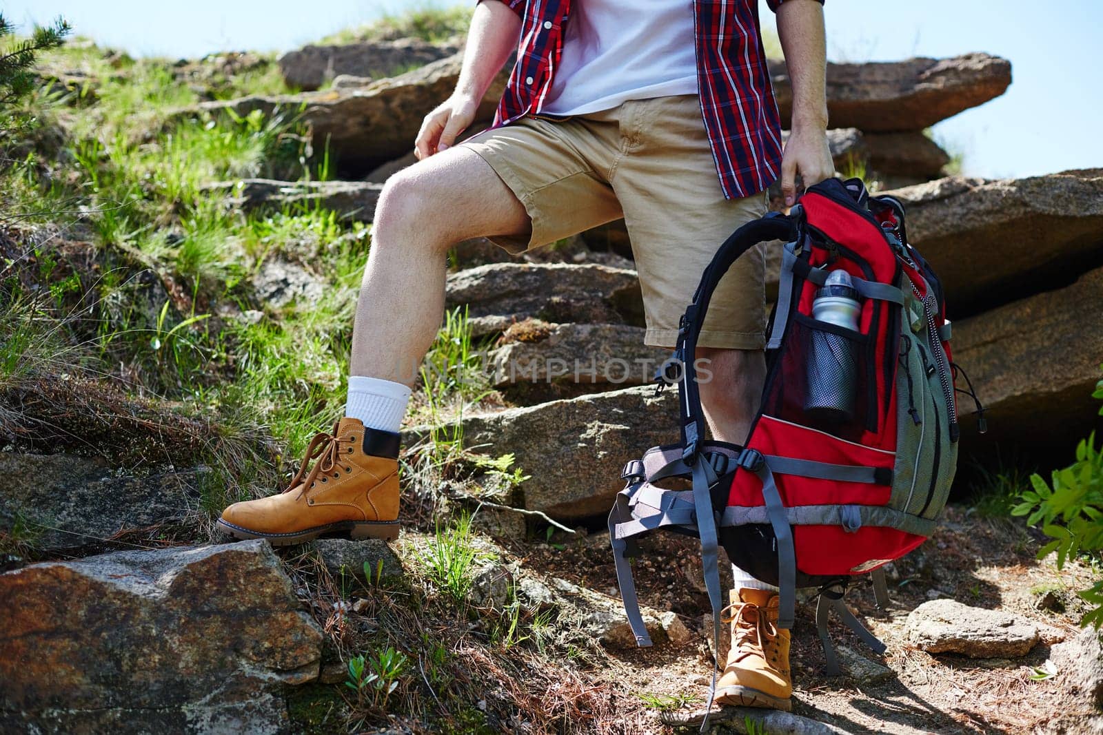 Young traveler with backpack standing on rock