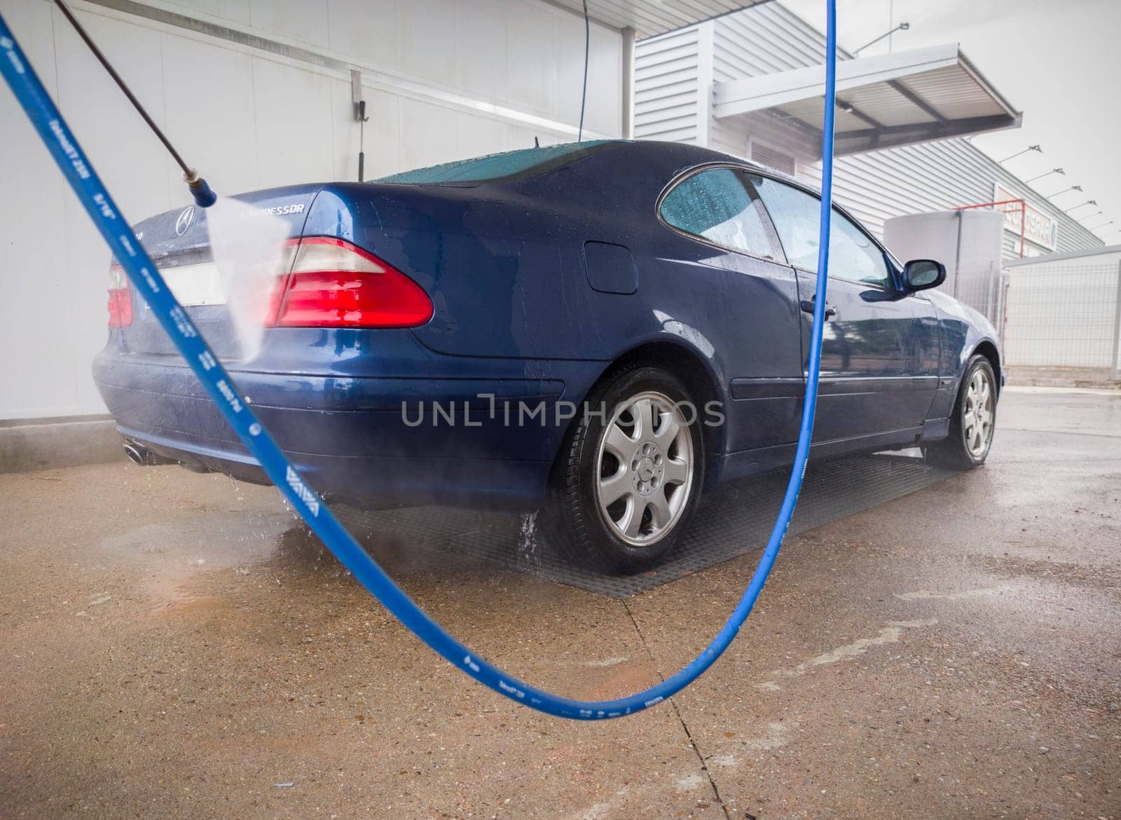 Washing with pressure a Mercedes-Benz CLK 320. Water jet pointing to trunk