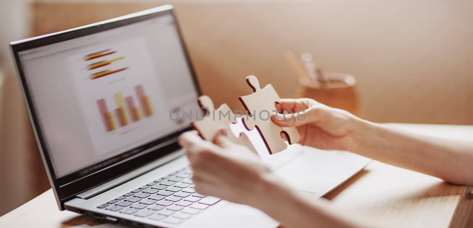 Woman holding pieces of puzzle in the office. Concept of solving problems and working together in company.